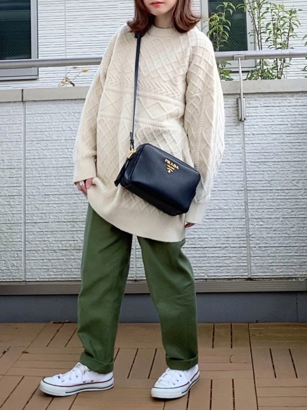 ホワイト系のニット/セーター、ブラック系のダウンジャケット/コート、グリーン系のその他パンツを着用したレディースの秋コーディネートの3枚目の写真