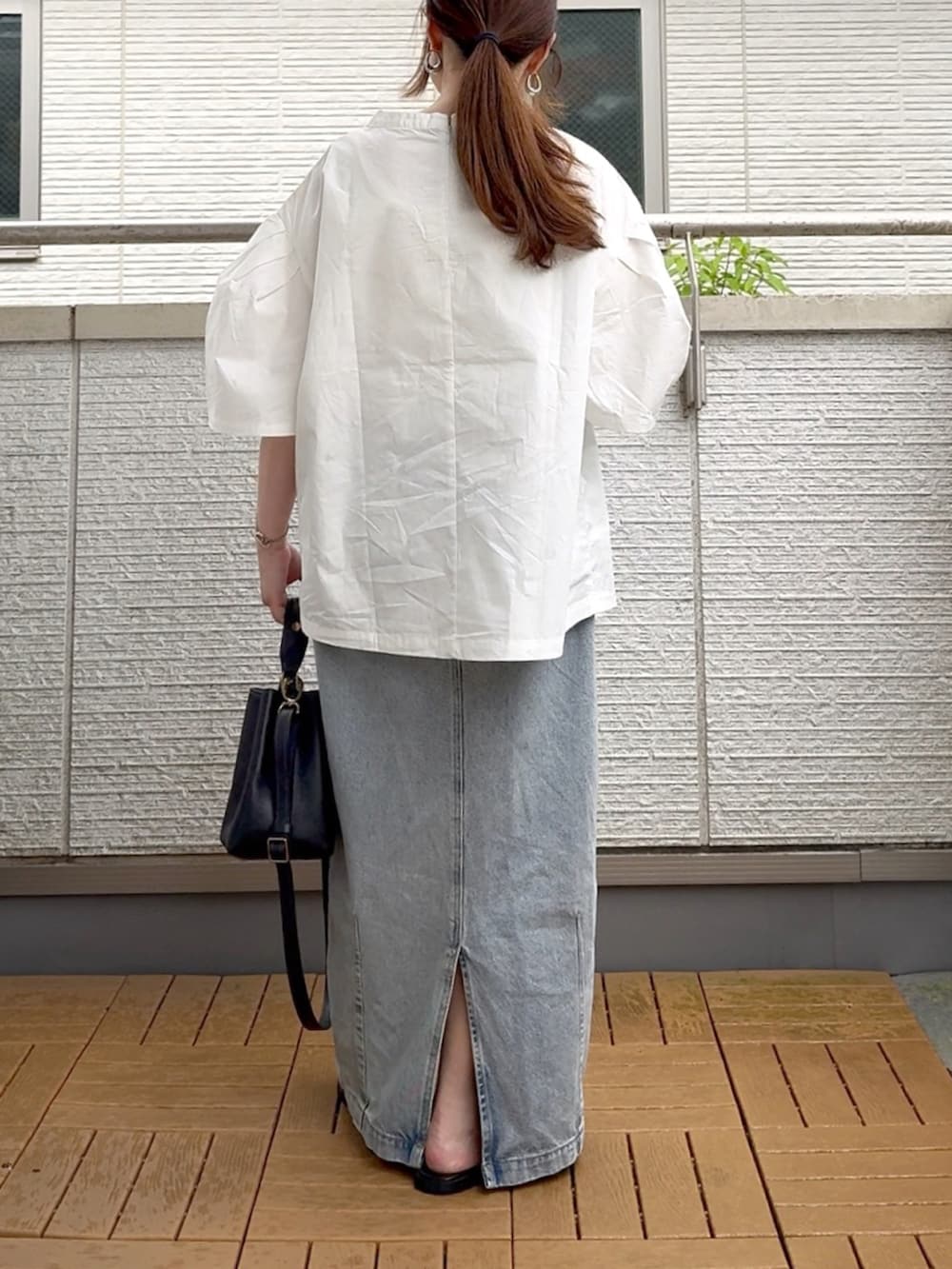ホワイト系のシャツ/ブラウス、ブルー系のデニムスカート、ブラック系のショルダーバッグを着用したレディースの夏コーディネートの4枚目の写真