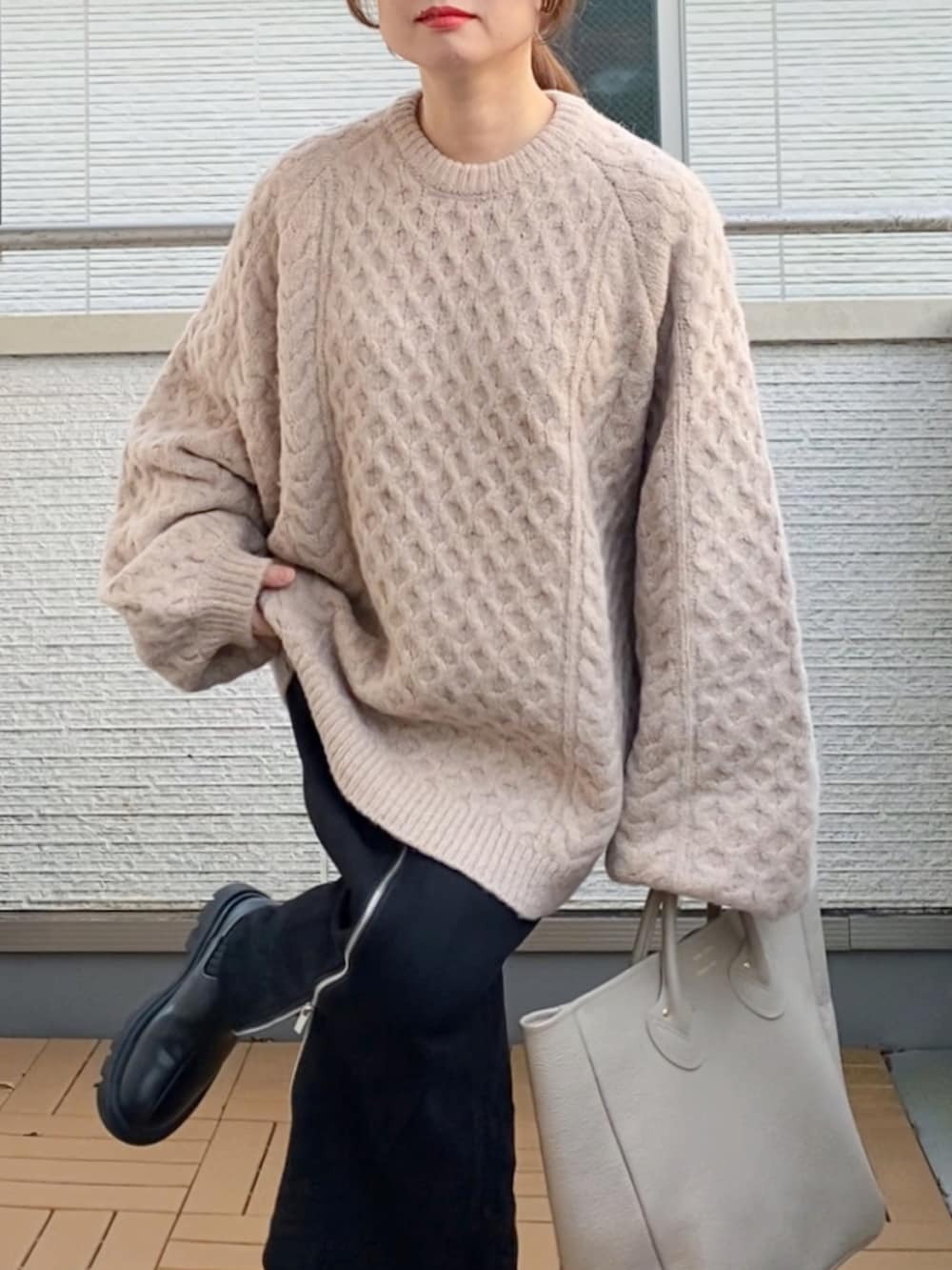 ベージュ系のニット/セーター、ブラック系のスカート、ベージュ系のトートバッグを着用したレディースの秋コーディネートの4枚目の写真