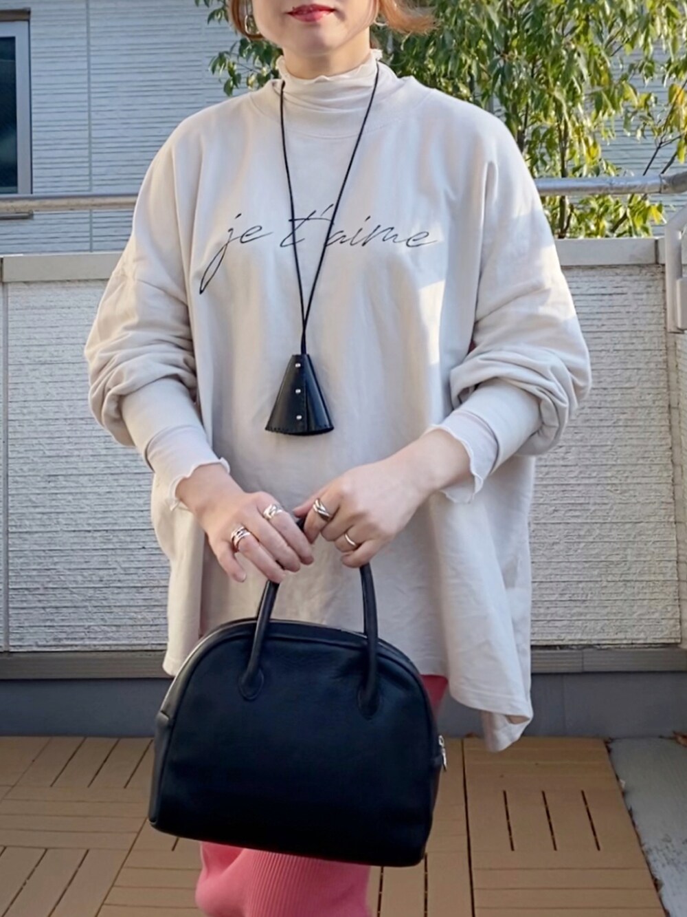 ホワイト系のスウェット、ホワイト系のTシャツ/カットソー、ピンク系のスカートを着用したレディースの冬コーディネートの3枚目の写真