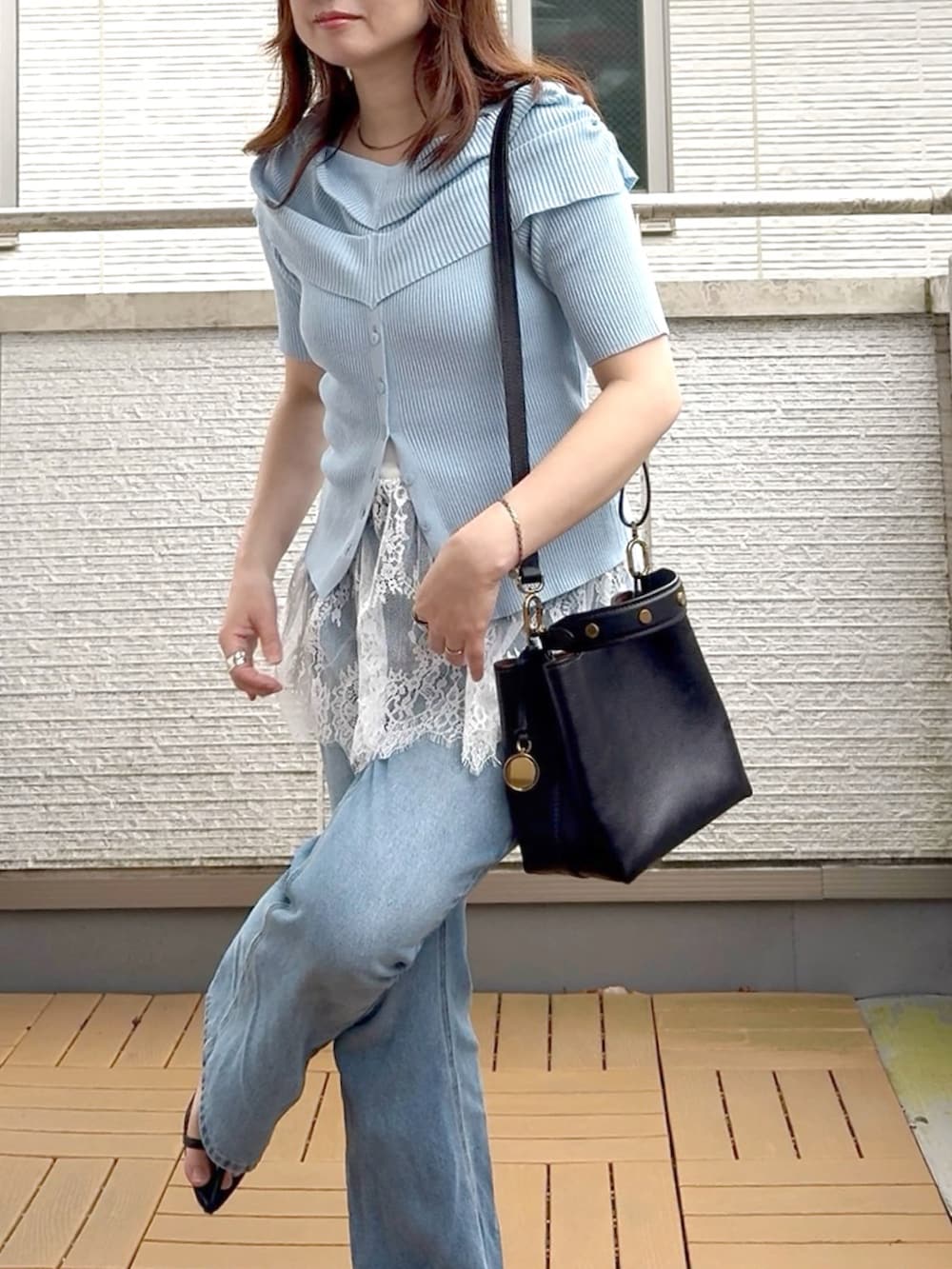 ブルー系のニット/セーター、ホワイト系のキャミソール、ブルー系のデニムパンツを着用したレディースの夏コーディネートの4枚目の写真