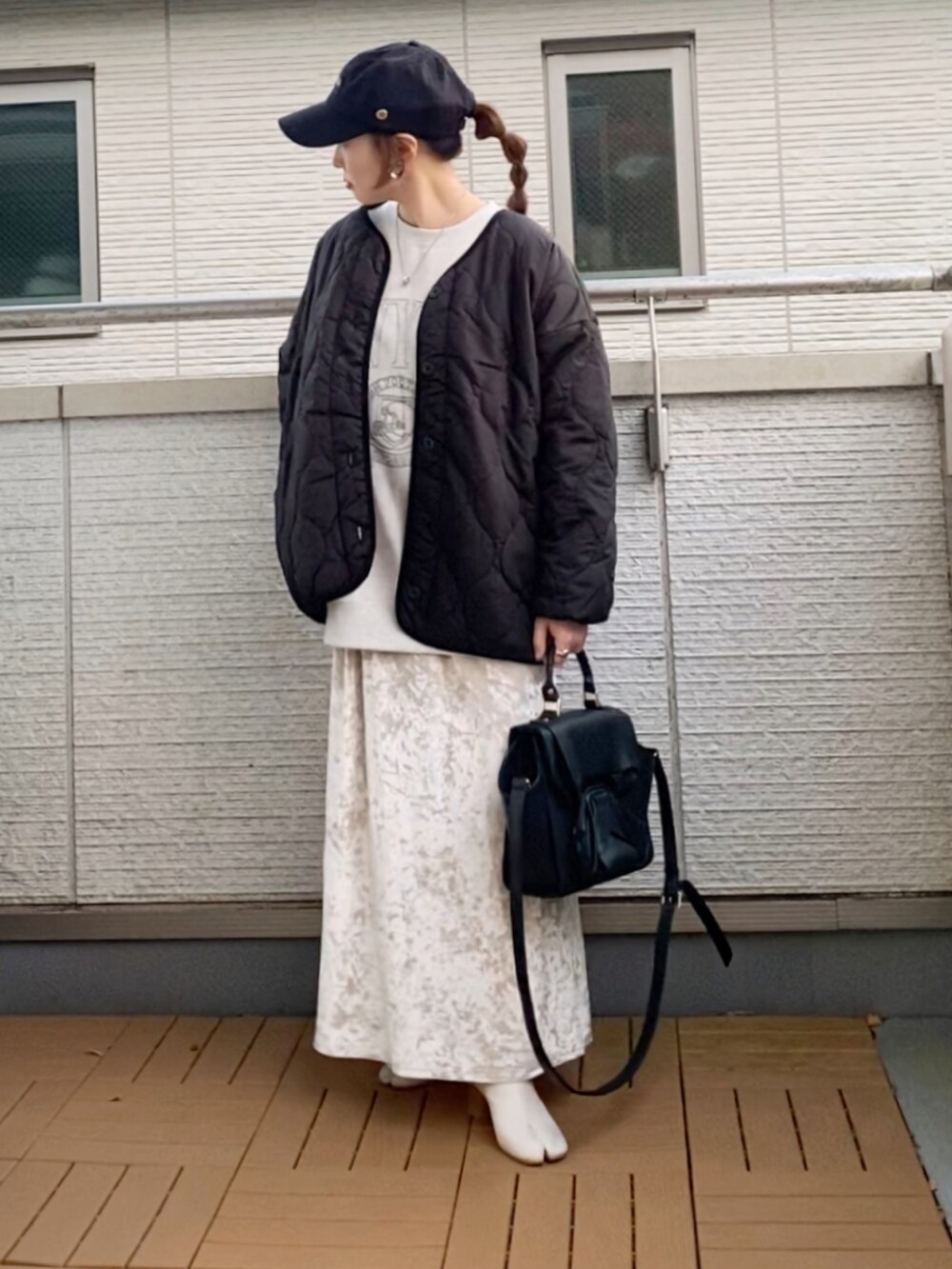 ブラック系のノーカラージャケット、グレー系のスウェット、ベージュ系のスカートを着用したレディースの冬コーディネートの2枚目の写真