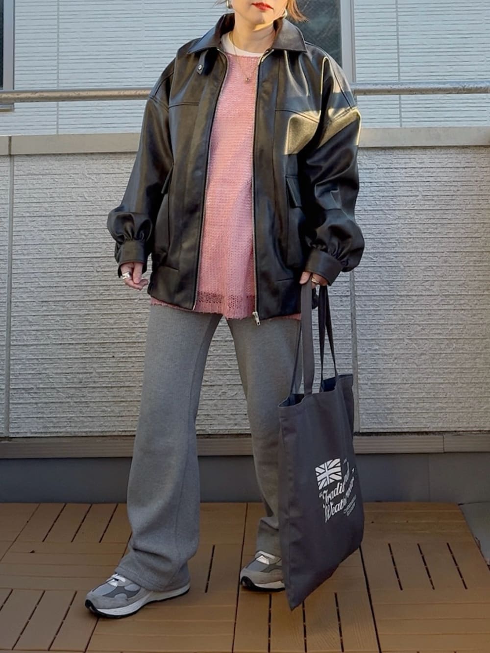 ブラック系のブルゾン、ピンク系のニット/セーター、グレー系のその他パンツを着用したレディースの冬コーディネートの2枚目の写真