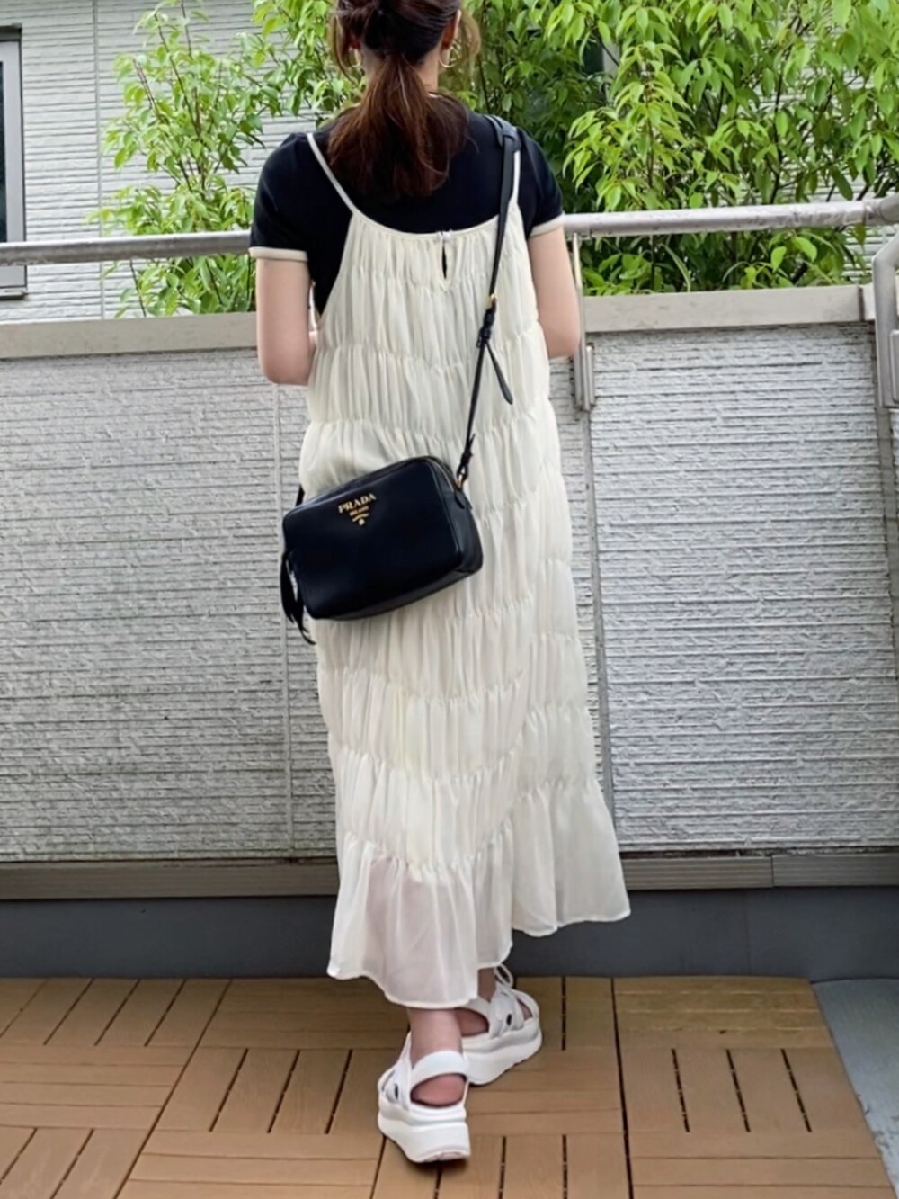 ホワイト系のワンピース、ブラック系のTシャツ/カットソー、ホワイト系のサンダルを着用したレディースの夏コーディネートの3枚目の写真