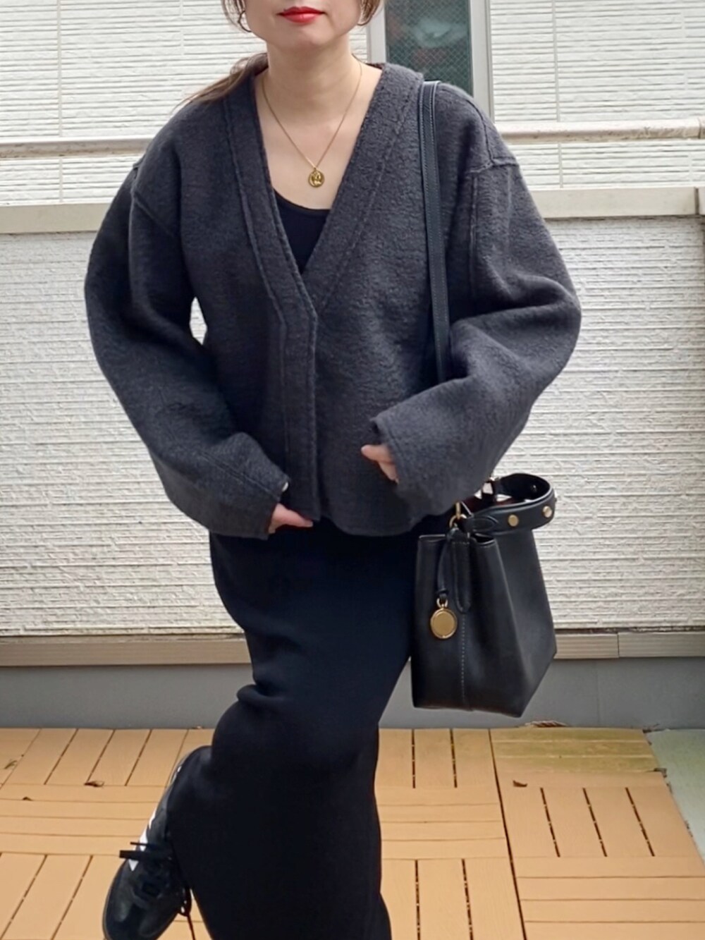 グレー系のカーディガン/ボレロ、ブラック系のワンピース、ブラック系のショルダーバッグを着用したレディースの秋コーディネートの4枚目の写真