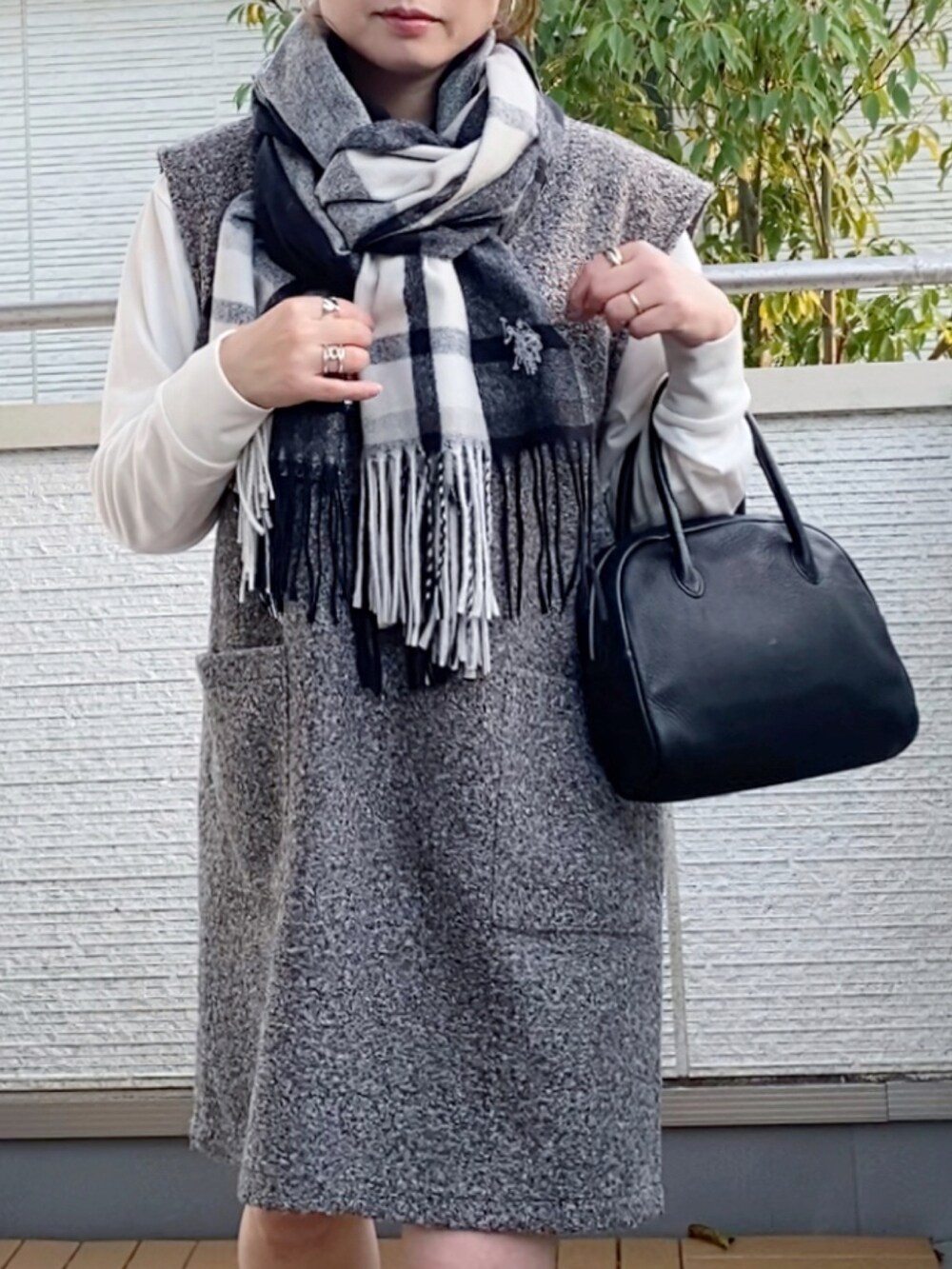 グレー系のジャンパースカート、グレー系のスニーカー、ブラック系のショルダーバッグを着用したレディースの秋コーディネートの4枚目の写真