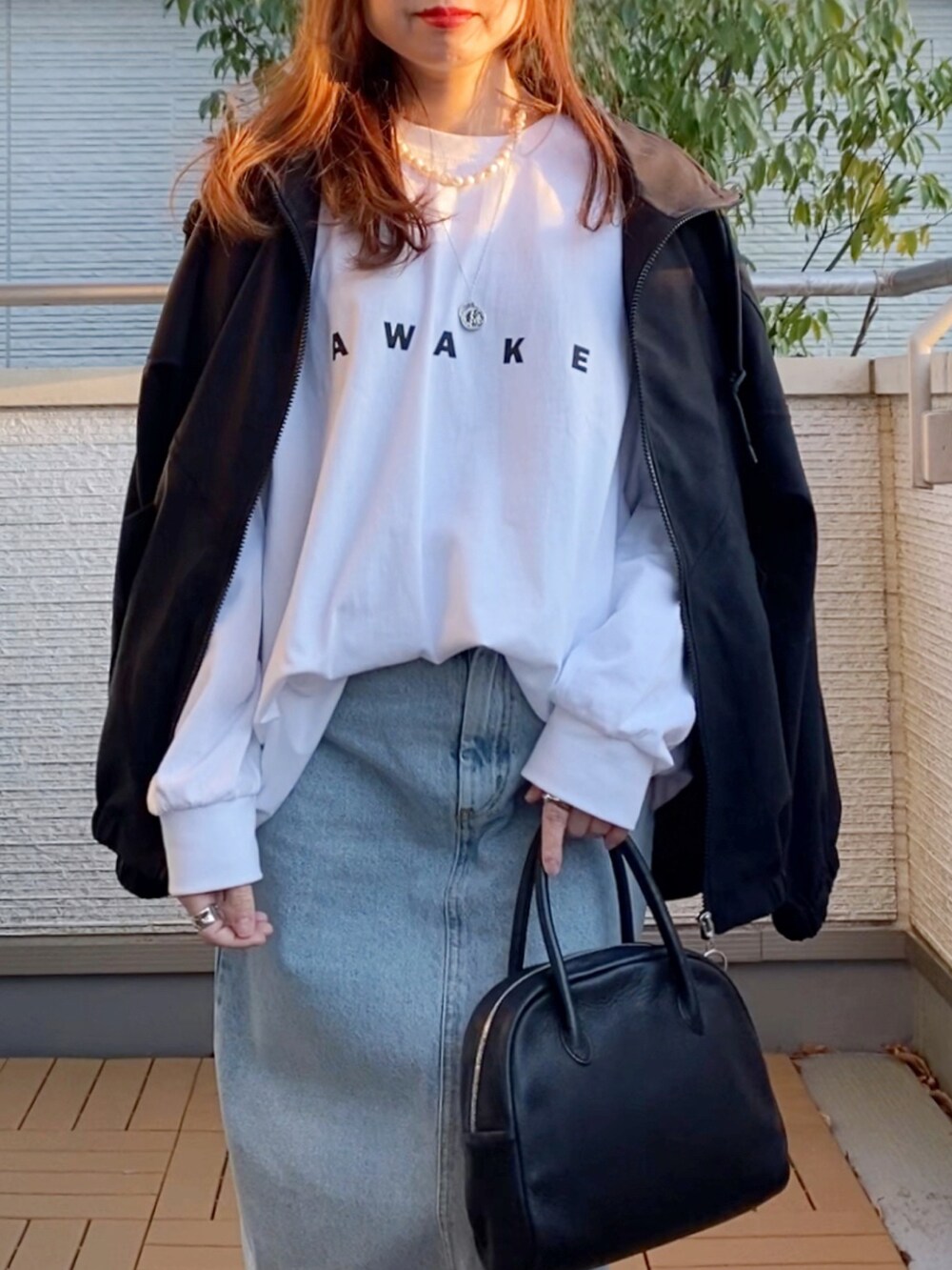 ホワイト系のTシャツ/カットソー、ブラック系のその他アウター、ブルー系のデニムスカートを着用したレディースの春コーディネートの2枚目の写真