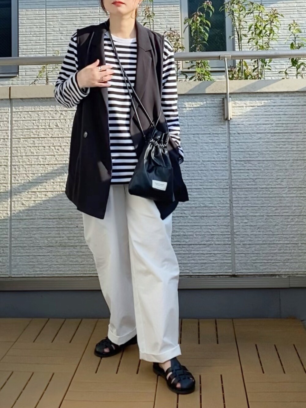 ブラック系のTシャツ/カットソー、ブラック系のベスト、ホワイト系のその他パンツを着用したレディースの春コーディネートの2枚目の写真