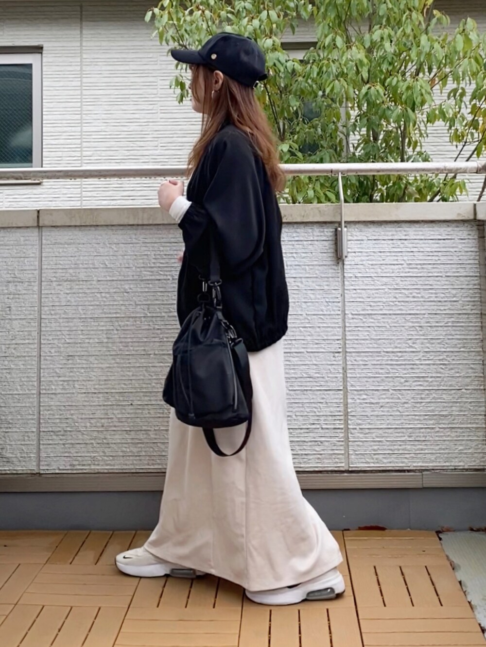 ブラック系のブルゾン、ホワイト系のワンピース、ホワイト系のTシャツ/カットソーを着用したレディースの春コーディネートの2枚目の写真
