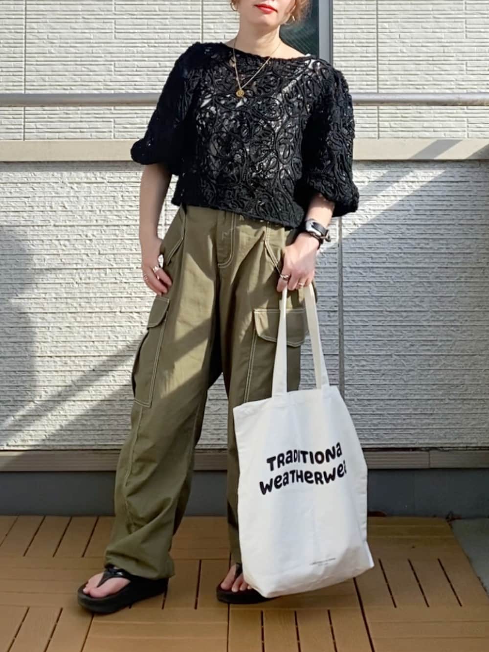 ブラック系のシャツ/ブラウス、グリーン系のカーゴパンツ、ホワイト系のトートバッグを着用したレディースの夏コーディネートの2枚目の写真