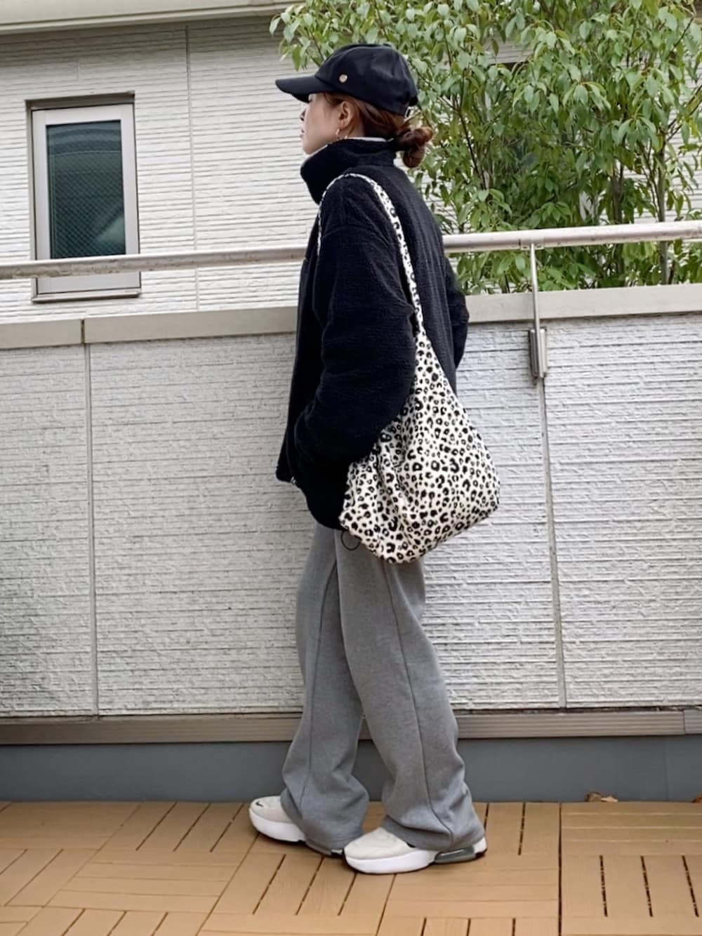 ブラック系のブルゾン、グレー系のその他パンツ、ホワイト系のトートバッグを着用したレディースの冬コーディネートの2枚目の写真