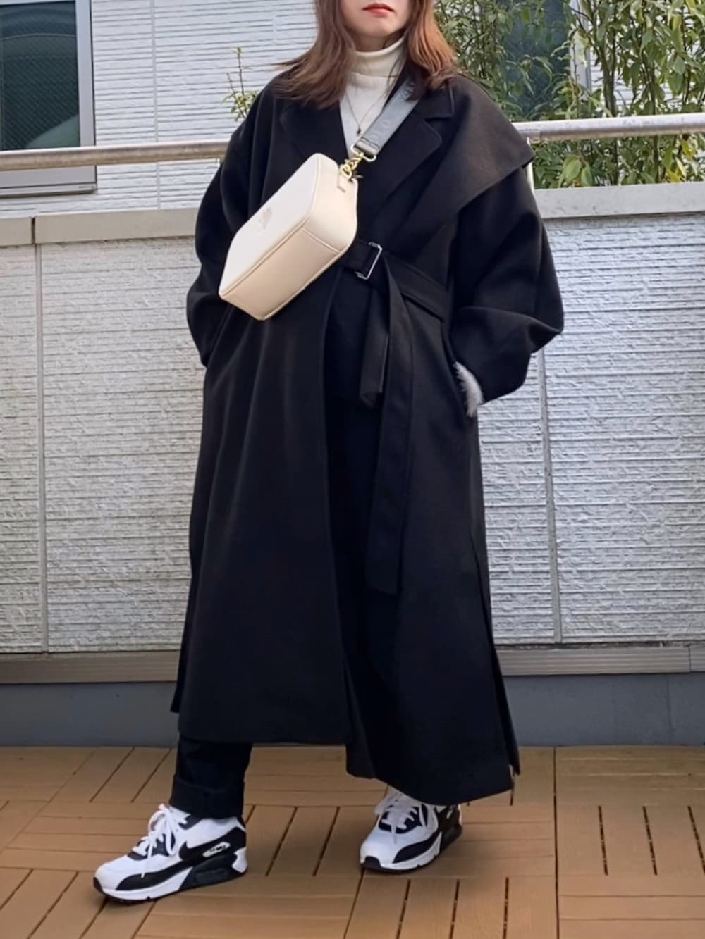 ブラック系のその他アウター、グレー系のカーディガン/ボレロ、ホワイト系のニット/セーターを着用したレディースの冬コーディネートの2枚目の写真