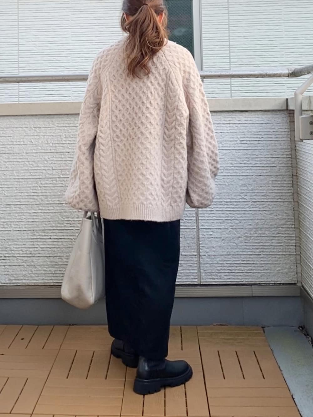 ベージュ系のニット/セーター、ブラック系のスカート、ベージュ系のトートバッグを着用したレディースの秋コーディネートの3枚目の写真