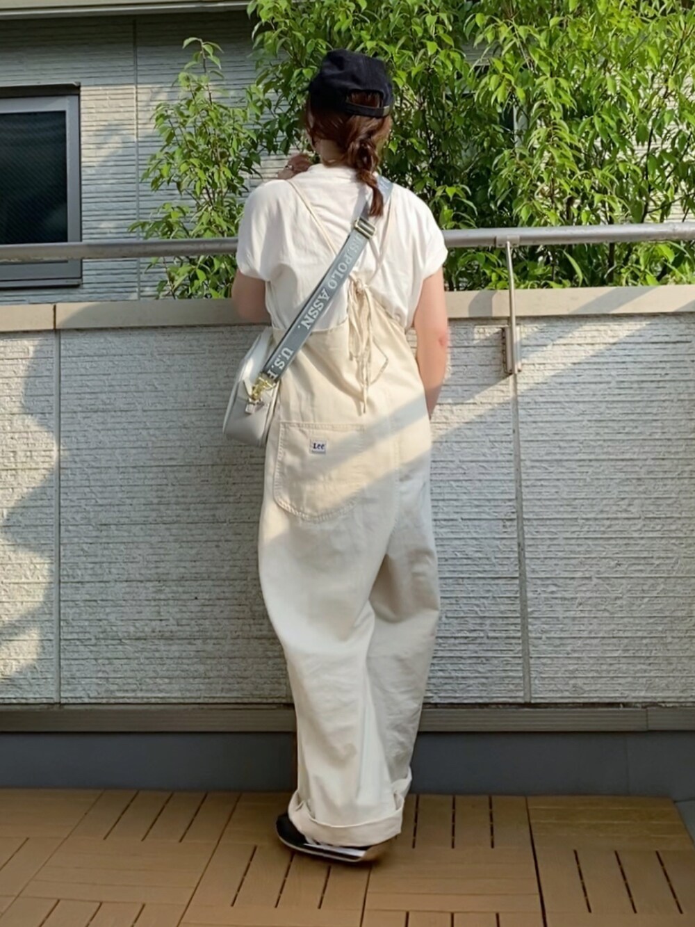 ホワイト系のサロペット/オーバーオール、ホワイト系のショルダーバッグ、ブラック系のスニーカーを着用したレディースの夏コーディネートの3枚目の写真