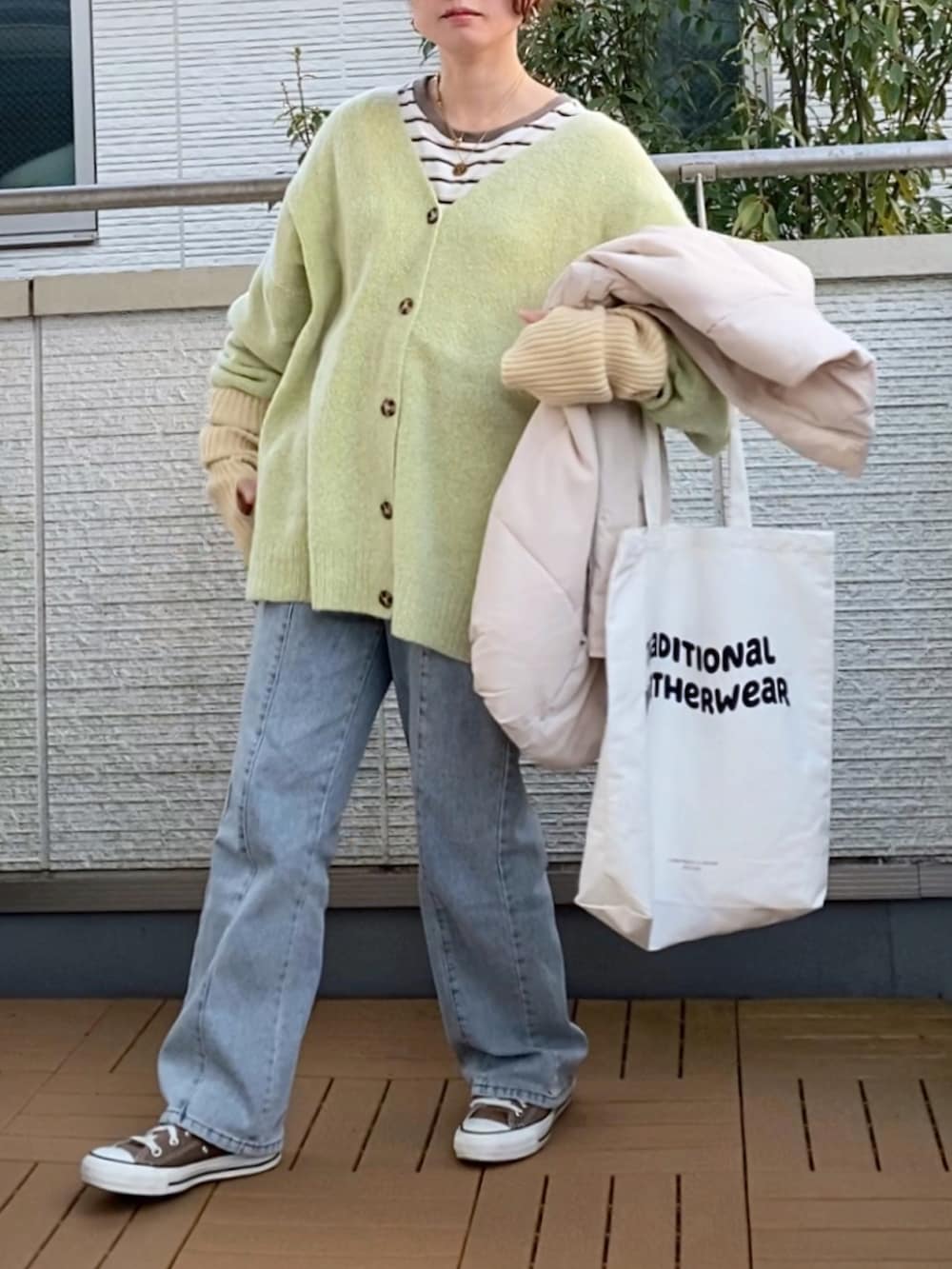 グリーン系のカーディガン/ボレロ、ホワイト系のダウンジャケット/コート、ホワイト系のTシャツ/カットソーを着用したレディースの冬コーディネートの2枚目の写真