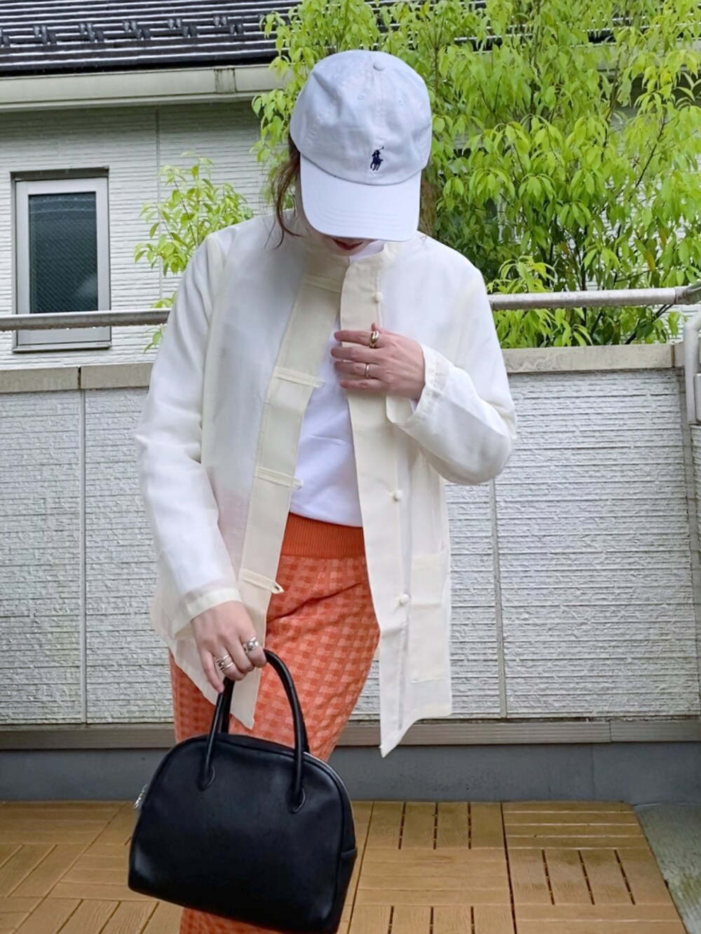 ホワイト系のシャツ/ブラウス、オレンジ系のその他パンツ、ブラック系のショルダーバッグを着用したレディースの春コーディネートの2枚目の写真