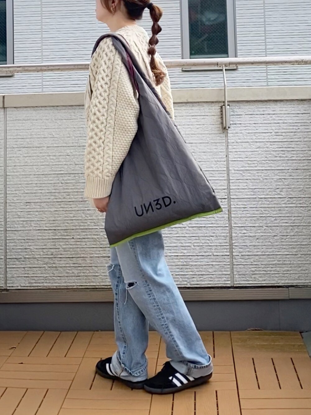 ホワイト系のニット/セーター、ブルー系のデニムパンツ、グレー系のトートバッグを着用したレディースの秋コーディネートの3枚目の写真