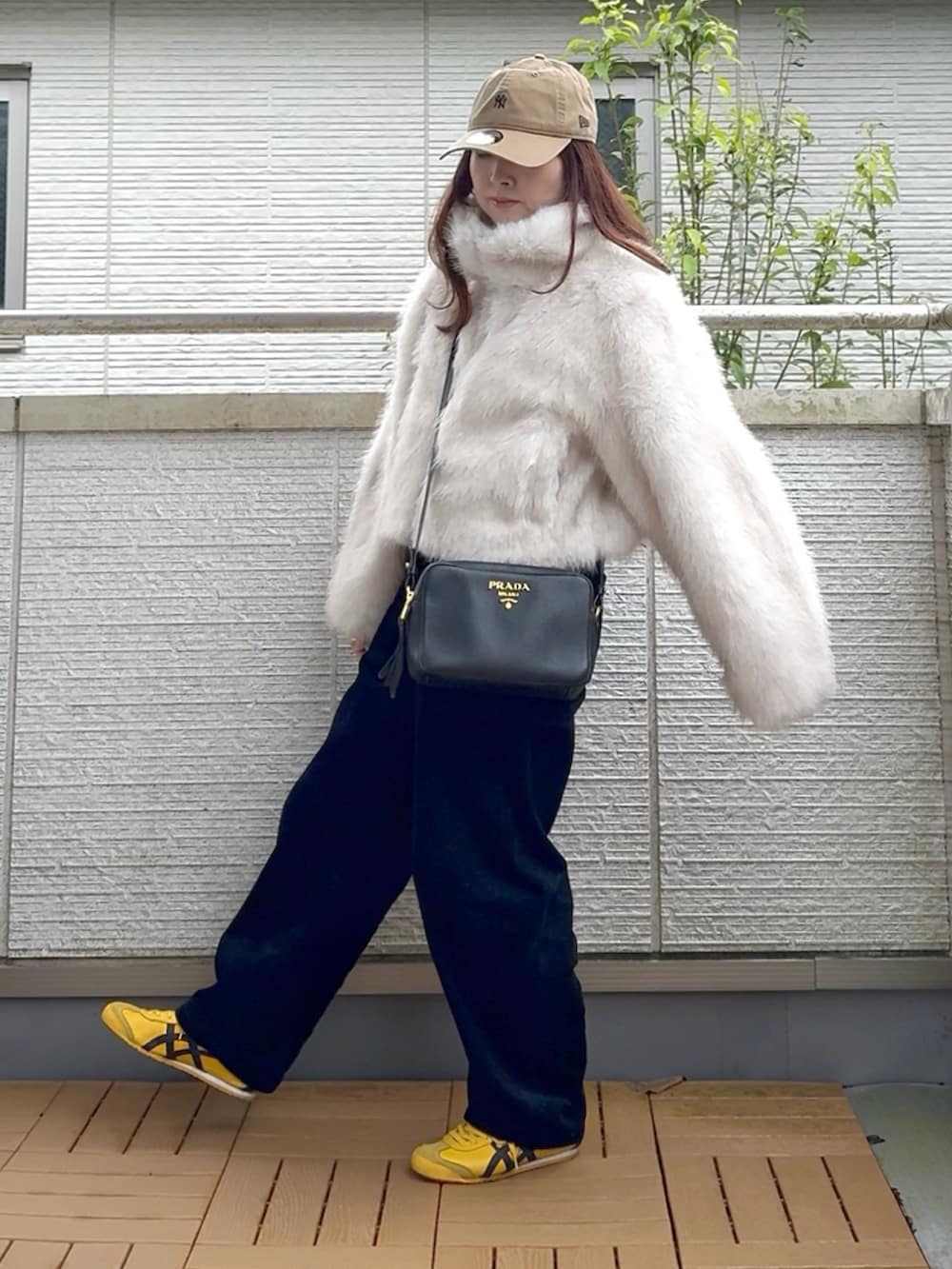 ホワイト系のブルゾン、ブラック系のその他パンツ、イエロー系のスニーカーを着用したレディースの秋コーディネートの2枚目の写真