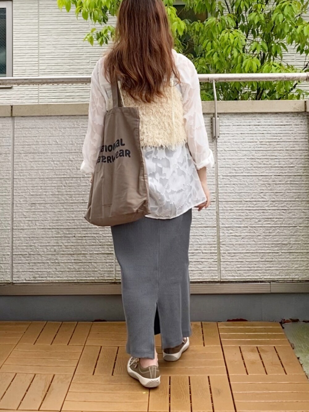 ホワイト系のベスト、ホワイト系のシャツ/ブラウス、グレー系のスカートを着用したレディースの春コーディネートの3枚目の写真