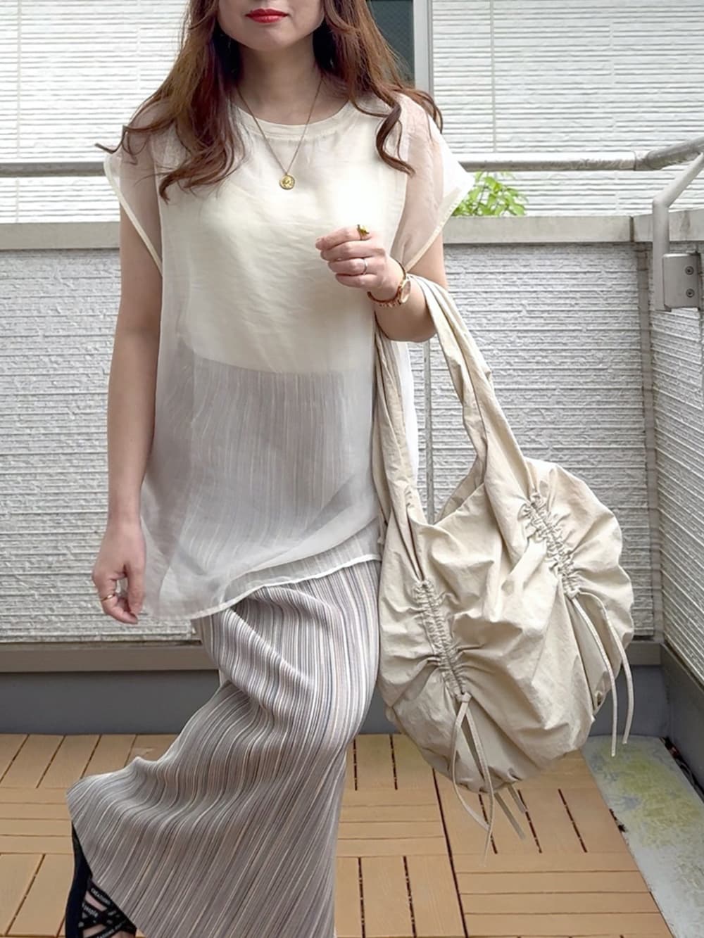 ホワイト系のTシャツ/カットソー、グレー系のスカート、ベージュ系のショルダーバッグを着用したレディースの春コーディネートの5枚目の写真