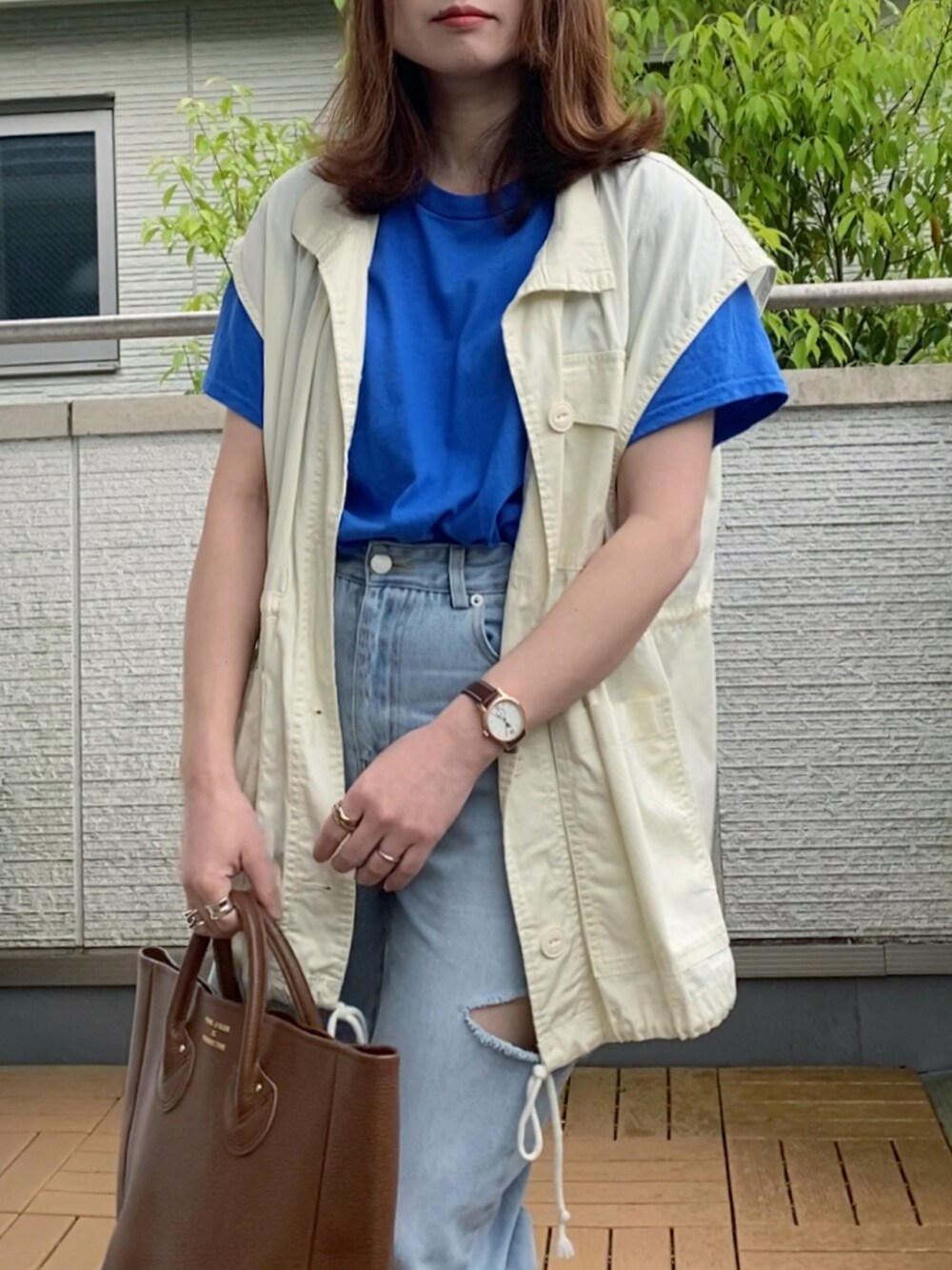 ブルー系のTシャツ/カットソー、ホワイト系のベスト、ブルー系のデニムパンツを着用したレディースの春コーディネートの3枚目の写真