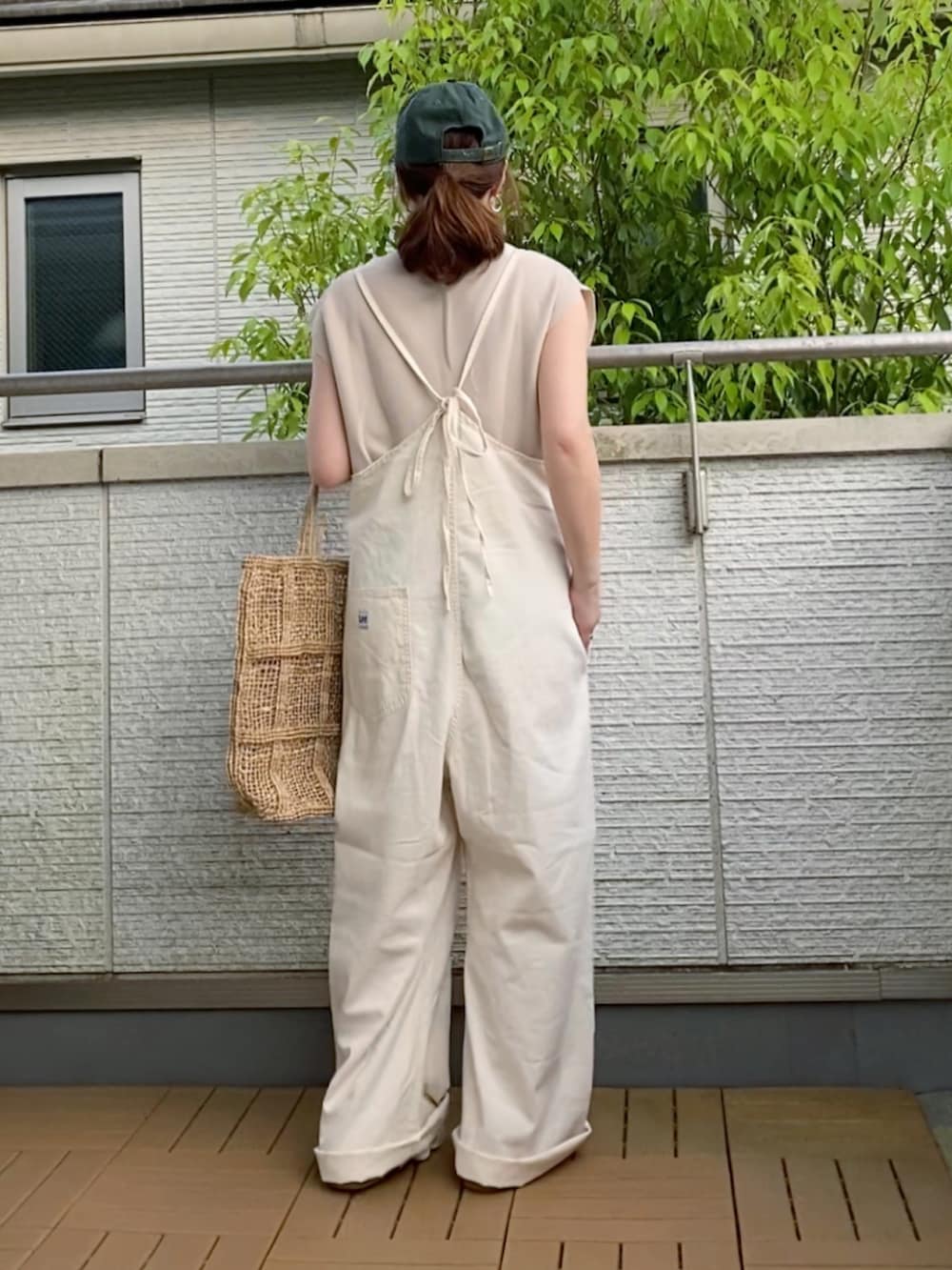 ベージュ系のニット/セーター、ベージュ系のバッグ、ブラウン系のサンダルを着用したレディースの春コーディネートの3枚目の写真