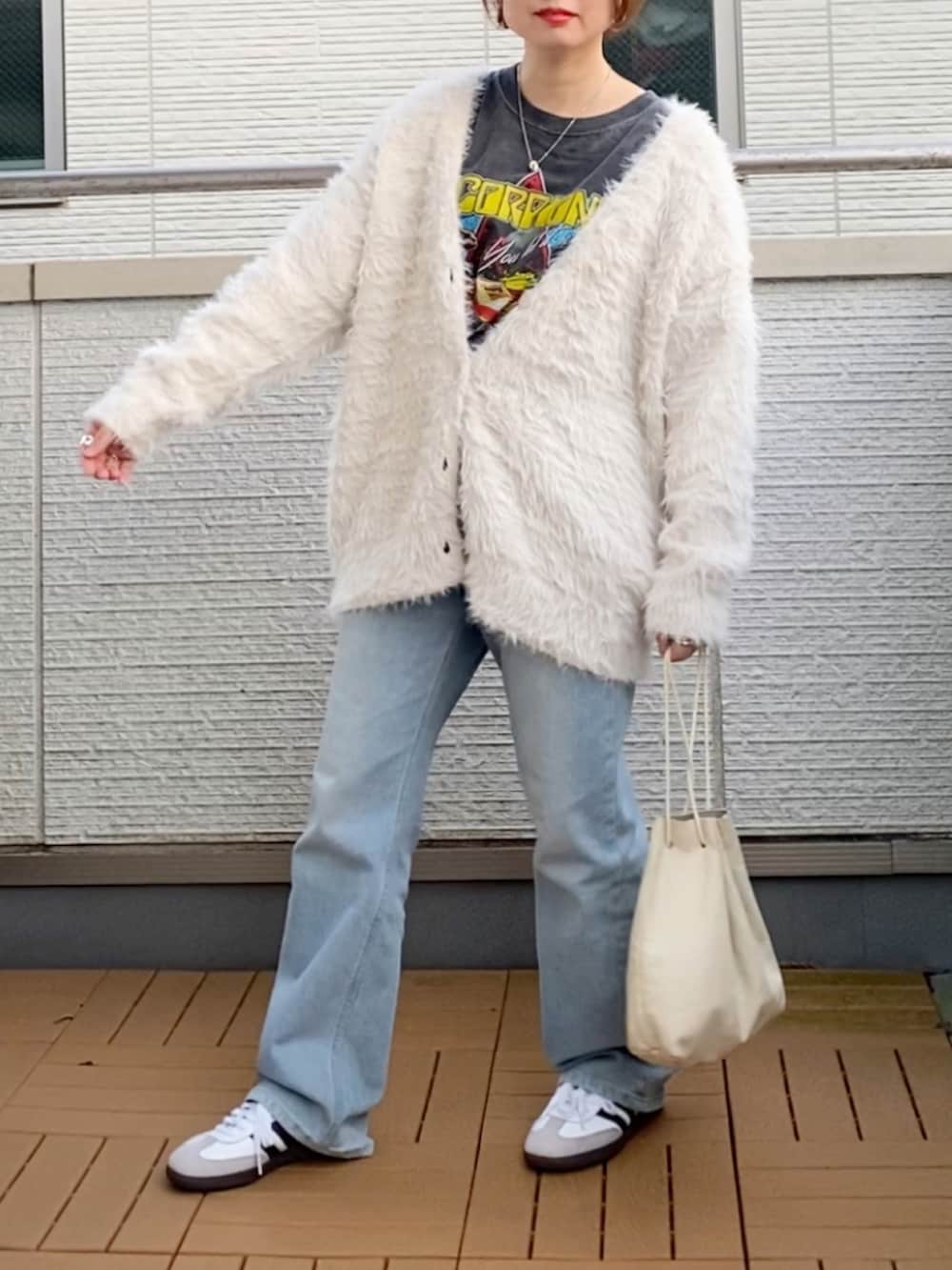 ホワイト系のカーディガン/ボレロ、ブラック系のTシャツ/カットソー、ブルー系のデニムパンツを着用したレディースの秋コーディネートの2枚目の写真