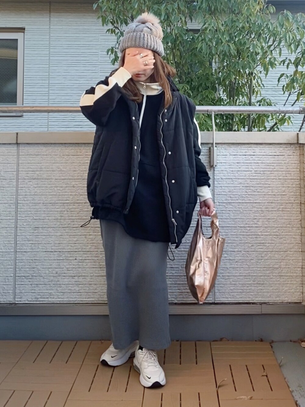 ブラック系のスウェット、ブラック系のベスト、グレー系のスカートを着用したレディースの冬コーディネートの2枚目の写真