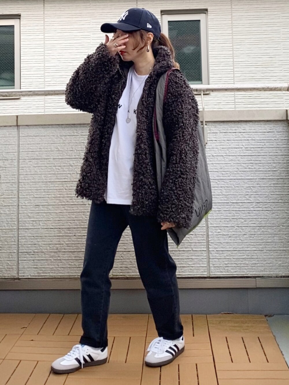 グレー系のブルゾン、ホワイト系のTシャツ/カットソー、グレー系のトートバッグを着用したレディースの秋コーディネートの2枚目の写真