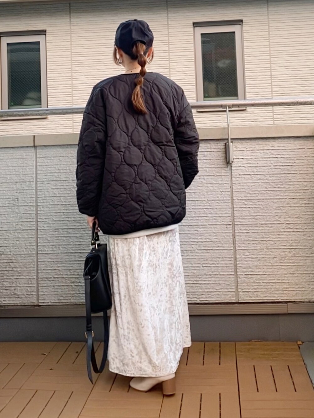 ブラック系のノーカラージャケット、グレー系のスウェット、ベージュ系のスカートを着用したレディースの冬コーディネートの3枚目の写真