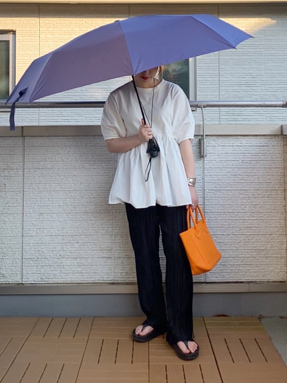 ホワイト系のTシャツ/カットソー、ブラック系のその他パンツ、オレンジ系のトートバッグを着用したレディースの夏コーディネートの2枚目の写真