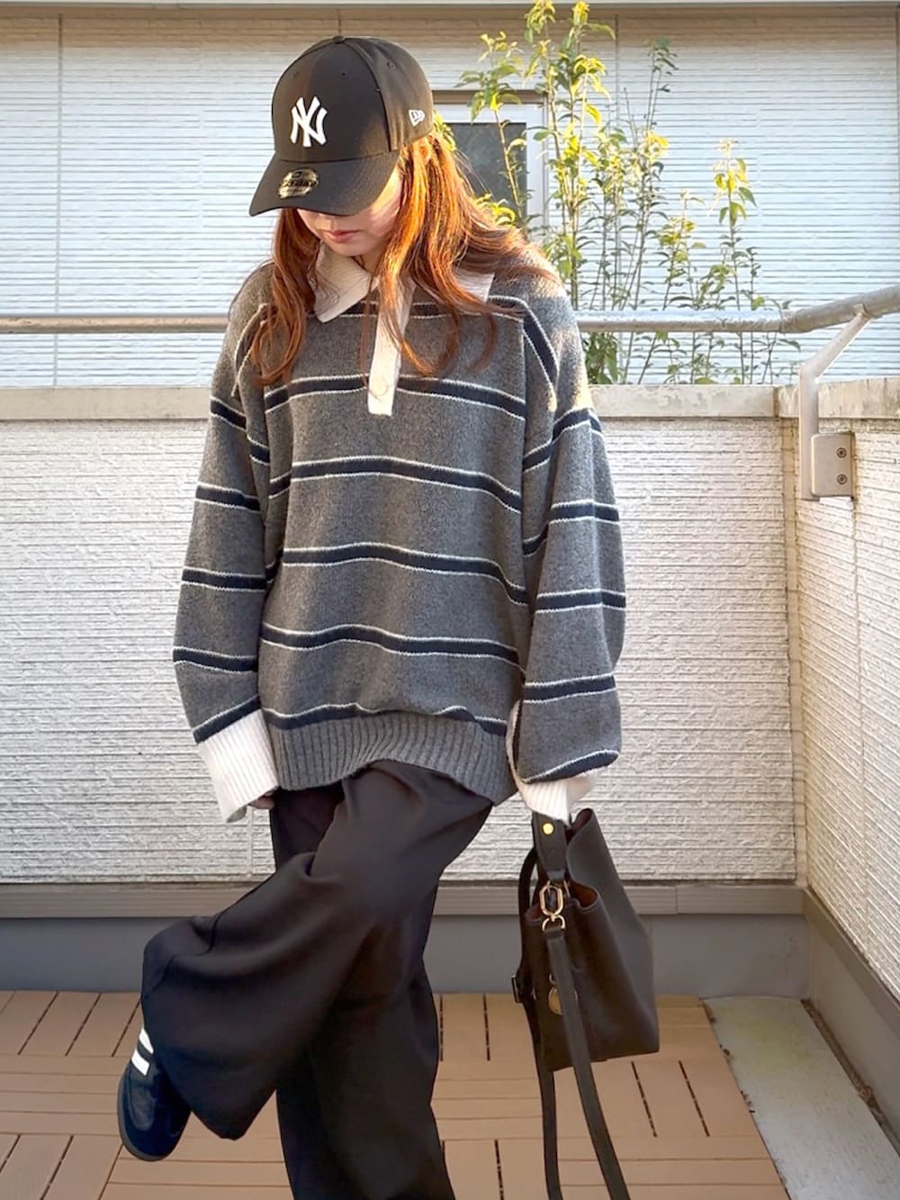 グレー系のニット/セーター、ブラック系のショルダーバッグ、ブラック系のスラックスを着用したレディースの冬コーディネートの4枚目の写真