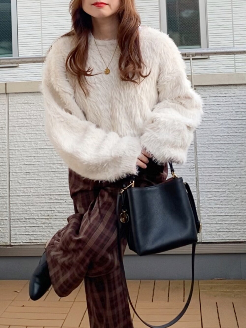 ホワイト系のニット/セーター、ブラウン系のその他パンツ、ブラック系のショルダーバッグを着用したレディースの冬コーディネートの5枚目の写真