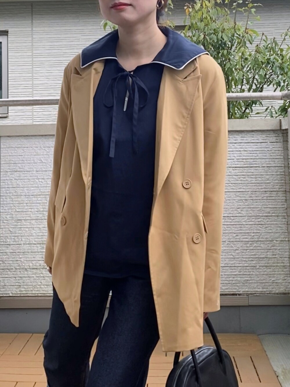 ベージュ系のテーラードジャケット、ブルー系のシャツ/ブラウス、ブルー系のデニムパンツを着用したレディースの春コーディネートの3枚目の写真