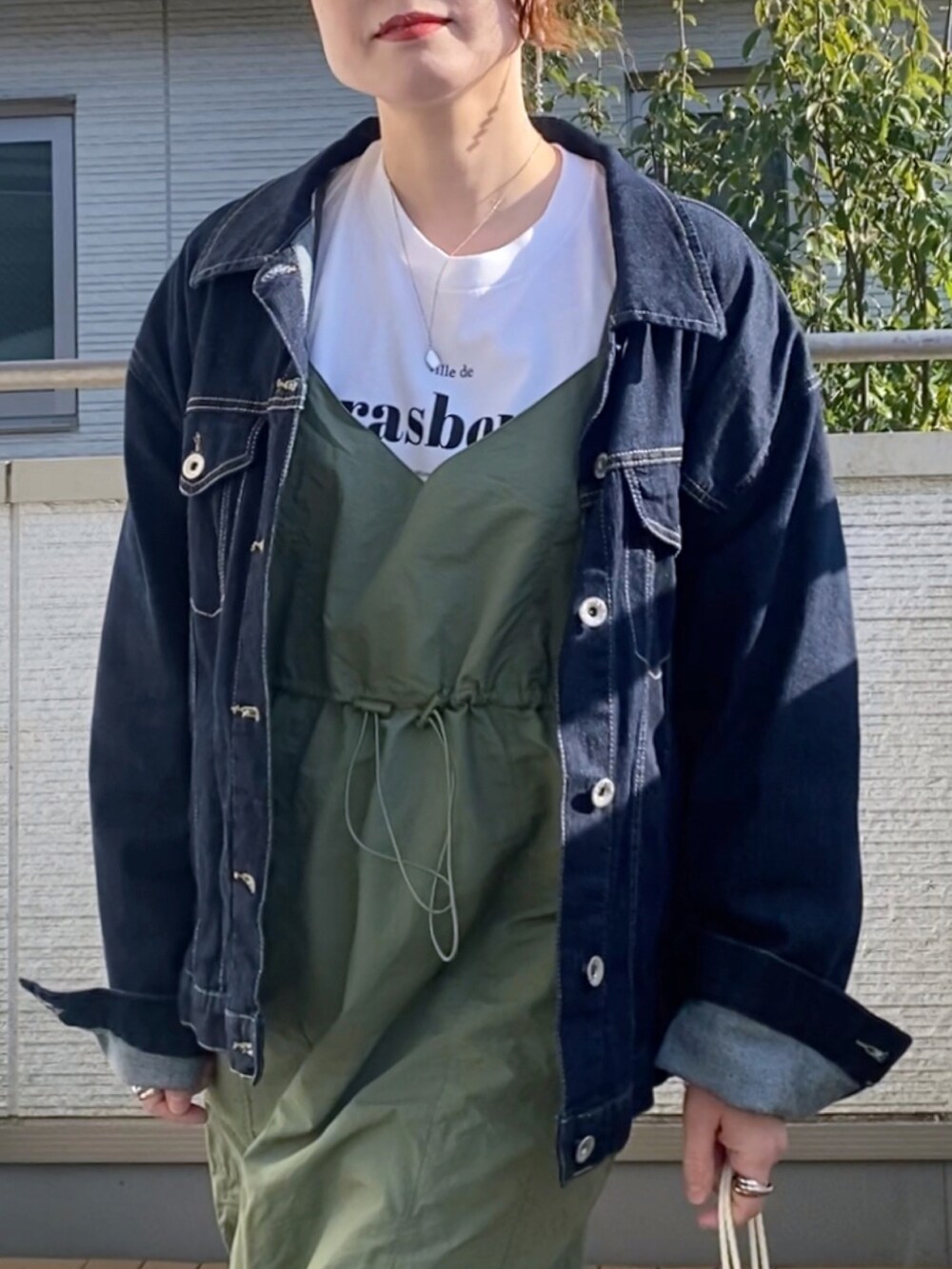 グリーン系のワンピース、ホワイト系のTシャツ/カットソー、ブルー系のデニムジャケットを着用したレディースの春コーディネートの2枚目の写真