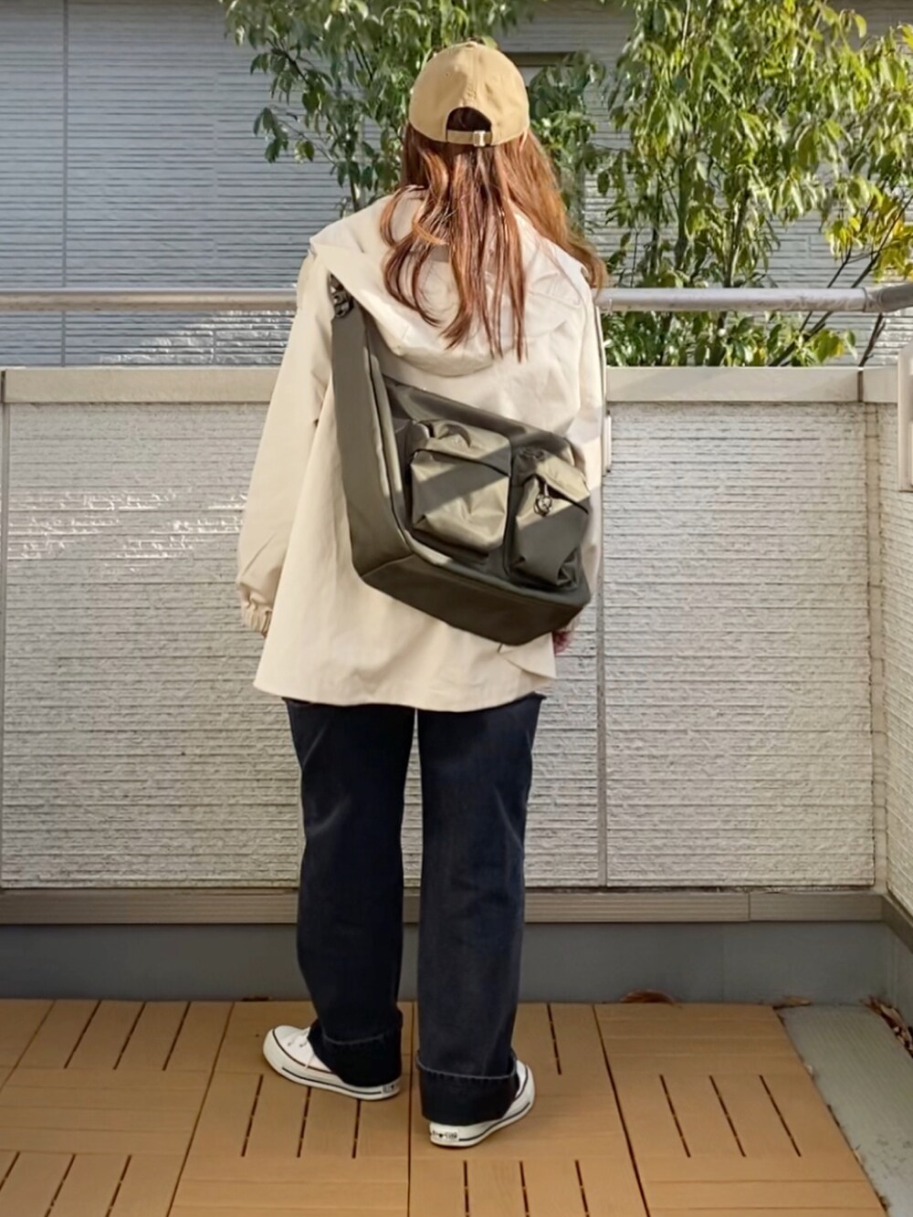 ホワイト系のマウンテンパーカー、ブラック系のTシャツ/カットソー、ブラック系のデニムパンツを着用したレディースの春コーディネートの4枚目の写真