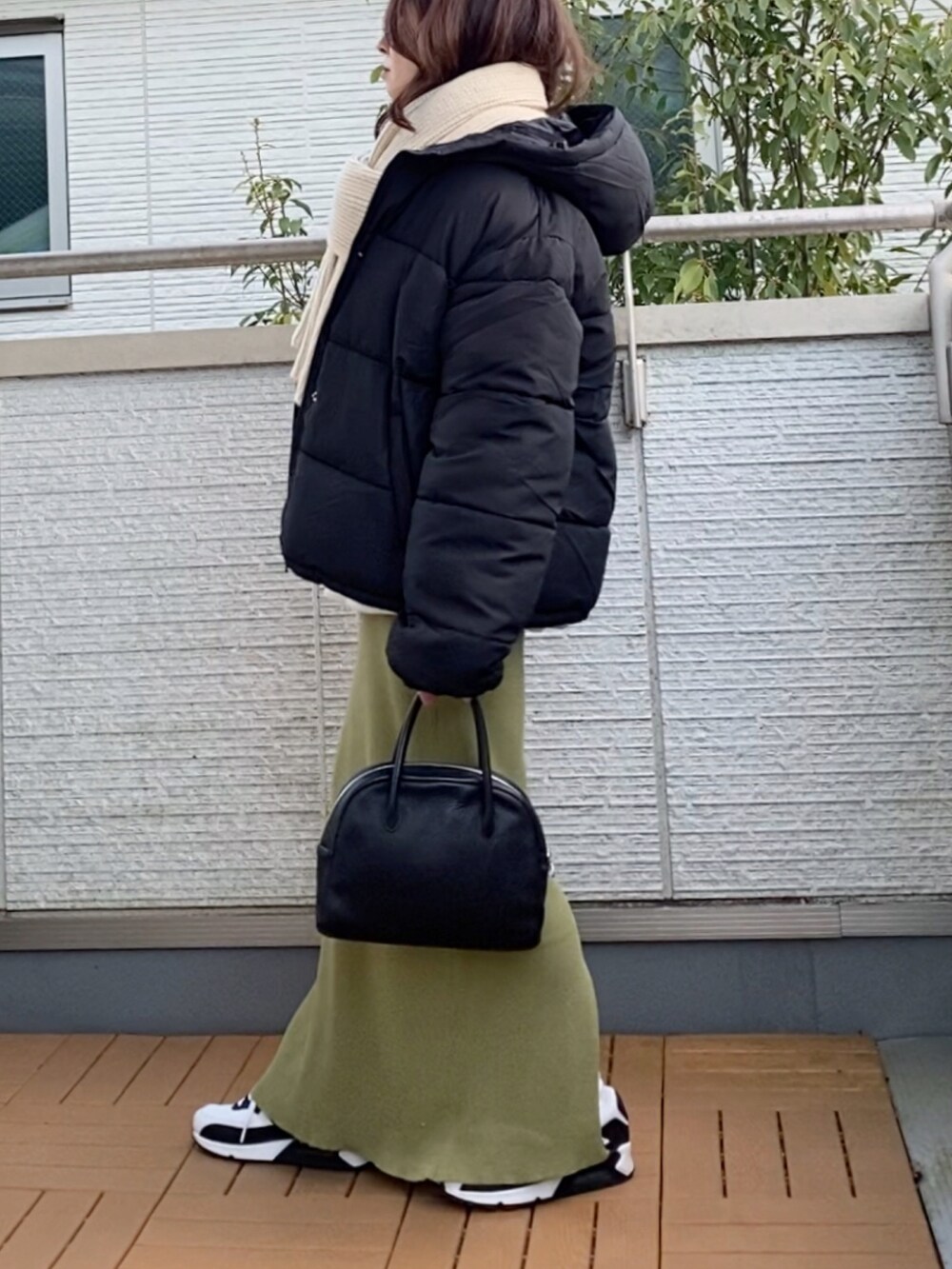 ブラック系のダウンジャケット/コート、グレー系のスウェット、グリーン系のスカートを着用したレディースの冬コーディネートの2枚目の写真