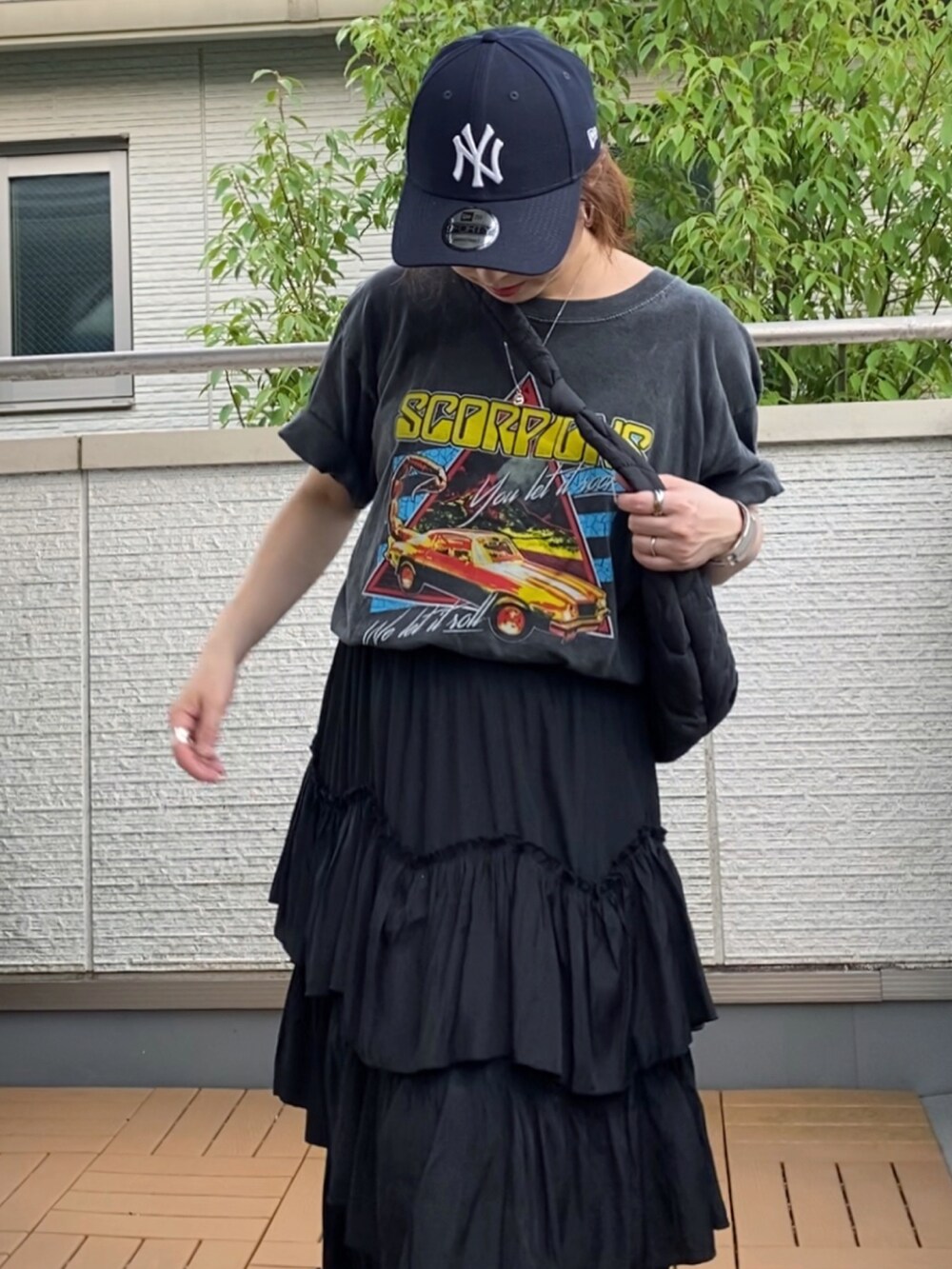 ブラック系のTシャツ/カットソー、ブラック系のスカート、ブラック系のショルダーバッグを着用したレディースの夏コーディネートの2枚目の写真