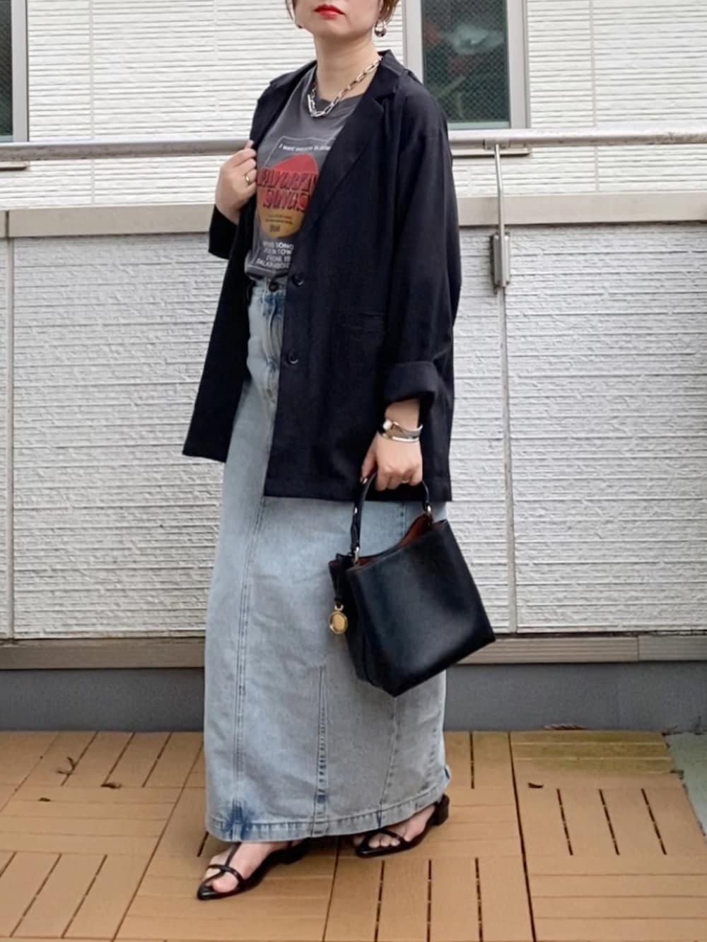 ブラック系のショルダーバッグ、ブラック系のテーラードジャケット、ブラック系のTシャツ/カットソーを着用したレディースの秋コーディネートの2枚目の写真