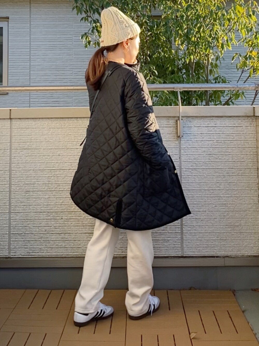 ブラック系のその他アウター、グリーン系のニット/セーター、ベージュ系のその他パンツを着用したレディースの冬コーディネートの2枚目の写真