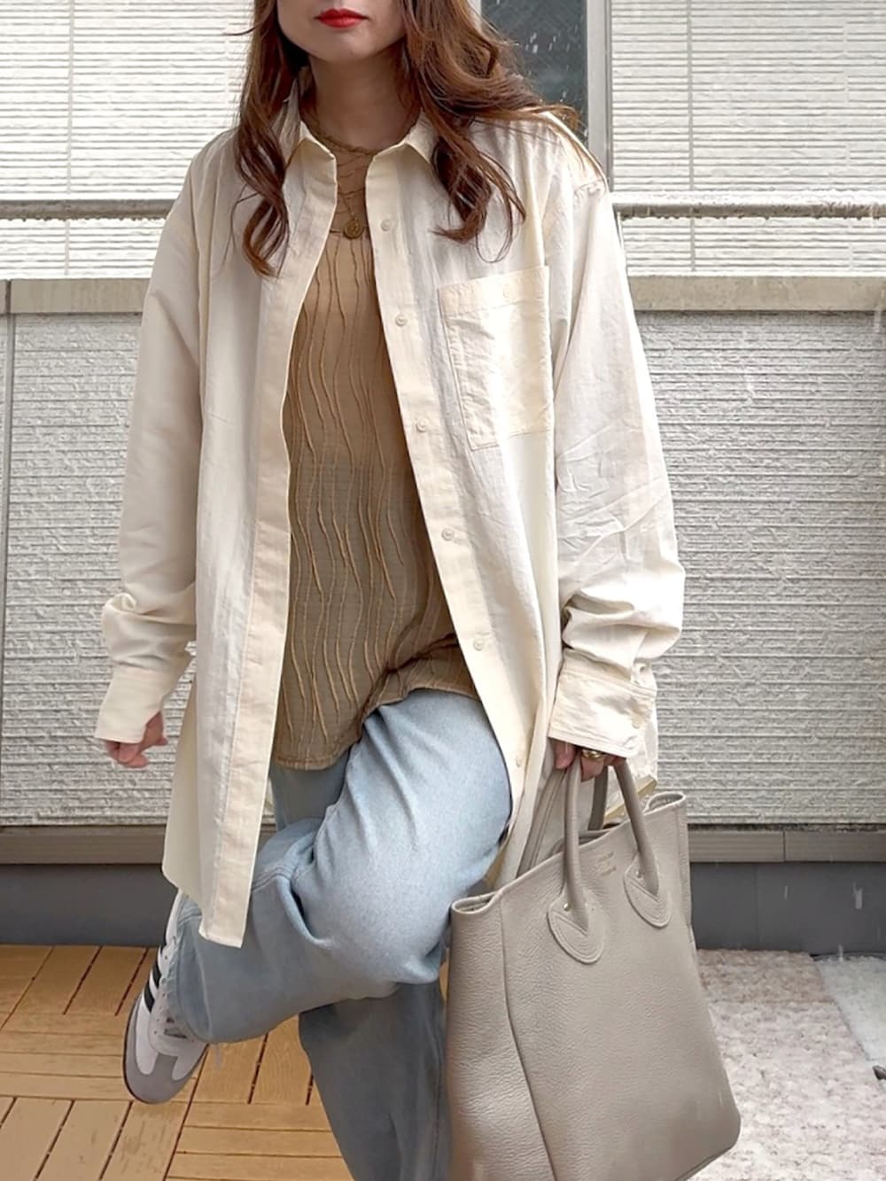 ホワイト系のシャツ/ブラウス、ベージュ系のTシャツ/カットソー、ブルー系のデニムパンツを着用したレディースの春コーディネートの5枚目の写真