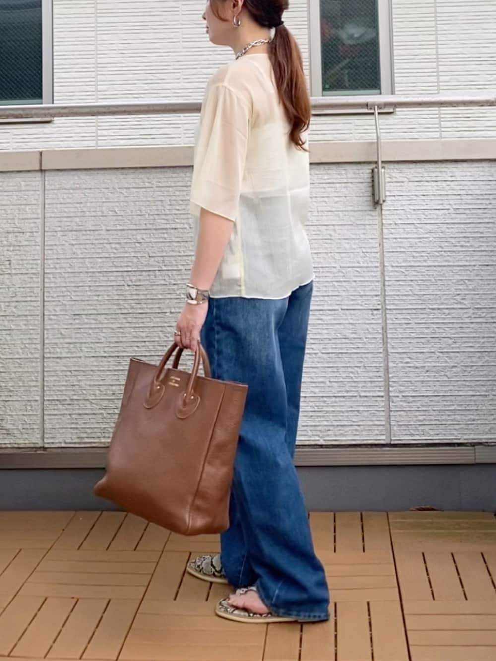 ホワイト系のシャツ/ブラウス、ブルー系のデニムパンツ、ブラウン系のトートバッグを着用したレディースの夏コーディネートの3枚目の写真