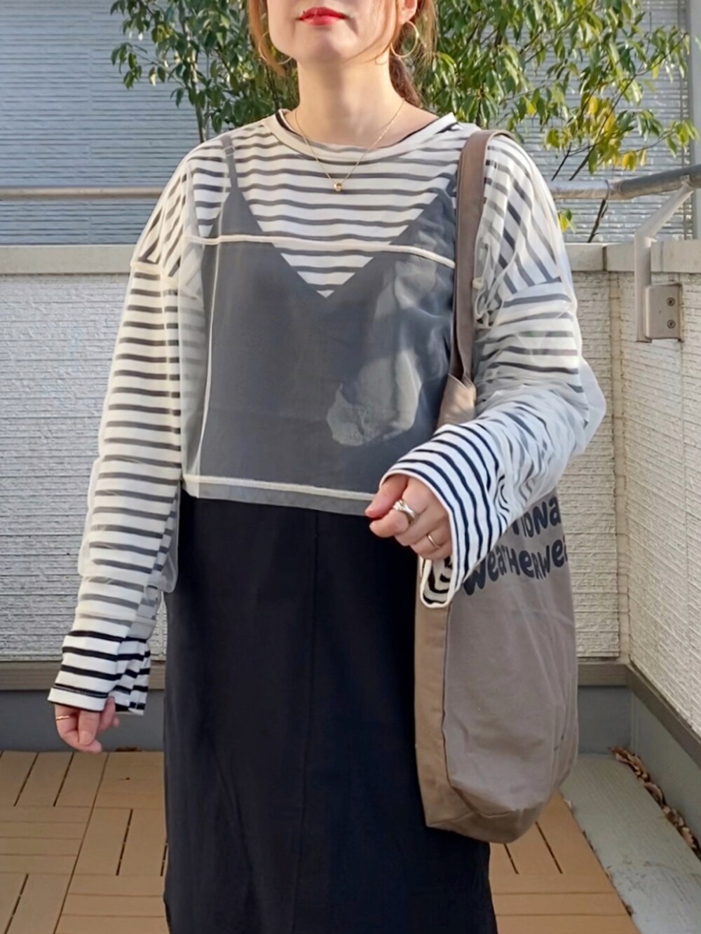 ホワイト系のTシャツ/カットソー、ブラック系のTシャツ/カットソー、ブラック系のワンピースを着用したレディースの春コーディネートの4枚目の写真