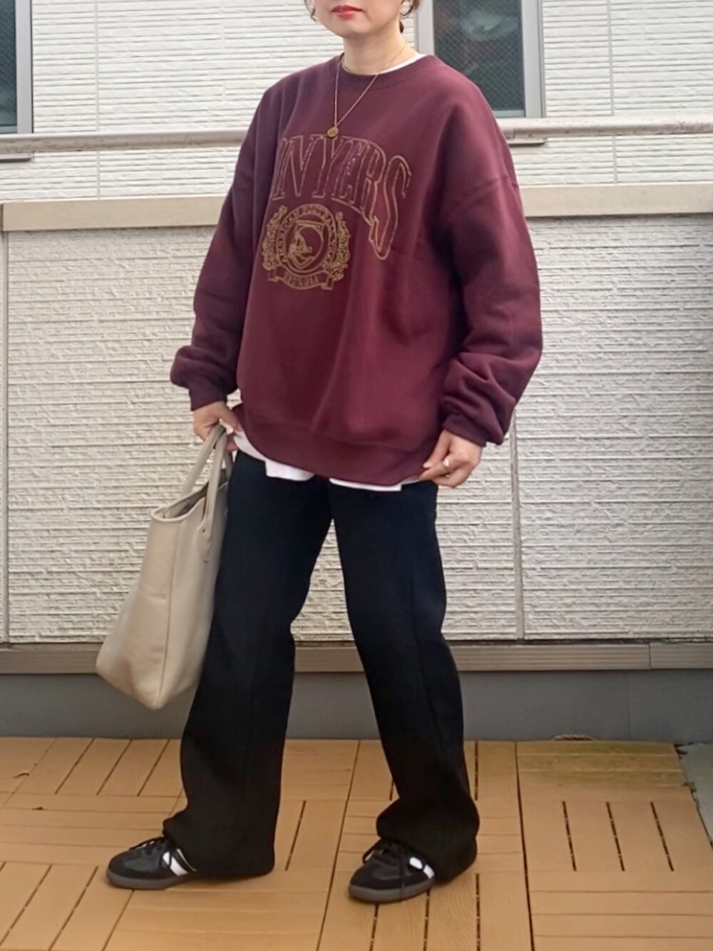 レッド系のスウェット、ブラック系のその他パンツ、ベージュ系のトートバッグを着用したレディースの秋コーディネートの2枚目の写真
