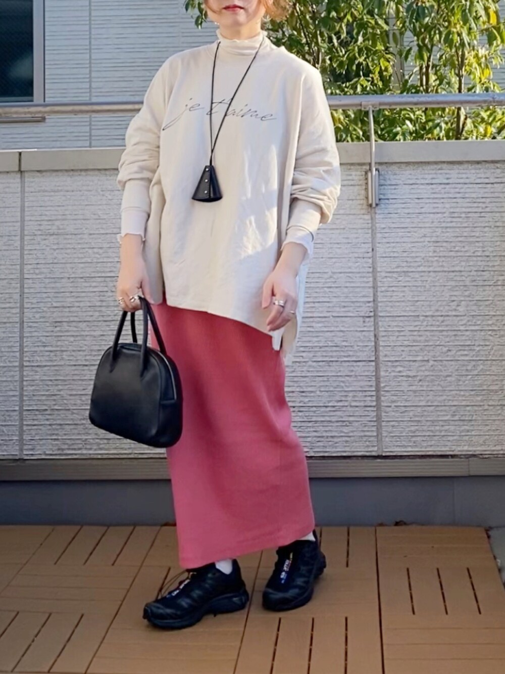 ホワイト系のスウェット、ホワイト系のTシャツ/カットソー、ピンク系のスカートを着用したレディースの冬コーディネートの2枚目の写真