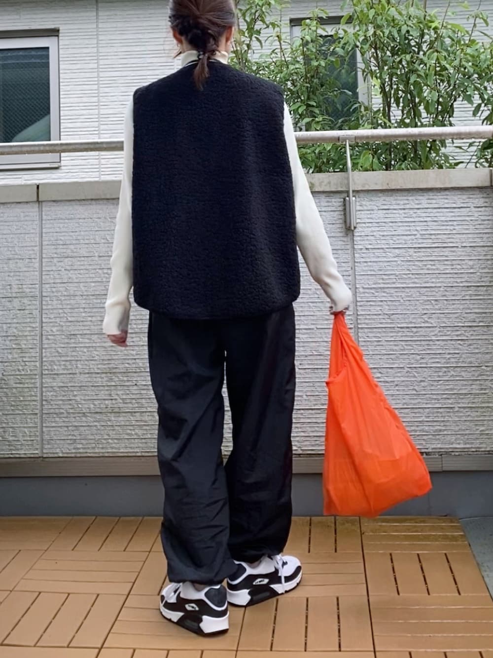 ブラック系のベスト、ホワイト系のニット/セーター、ブラック系のカーゴパンツを着用したレディースの秋コーディネートの2枚目の写真