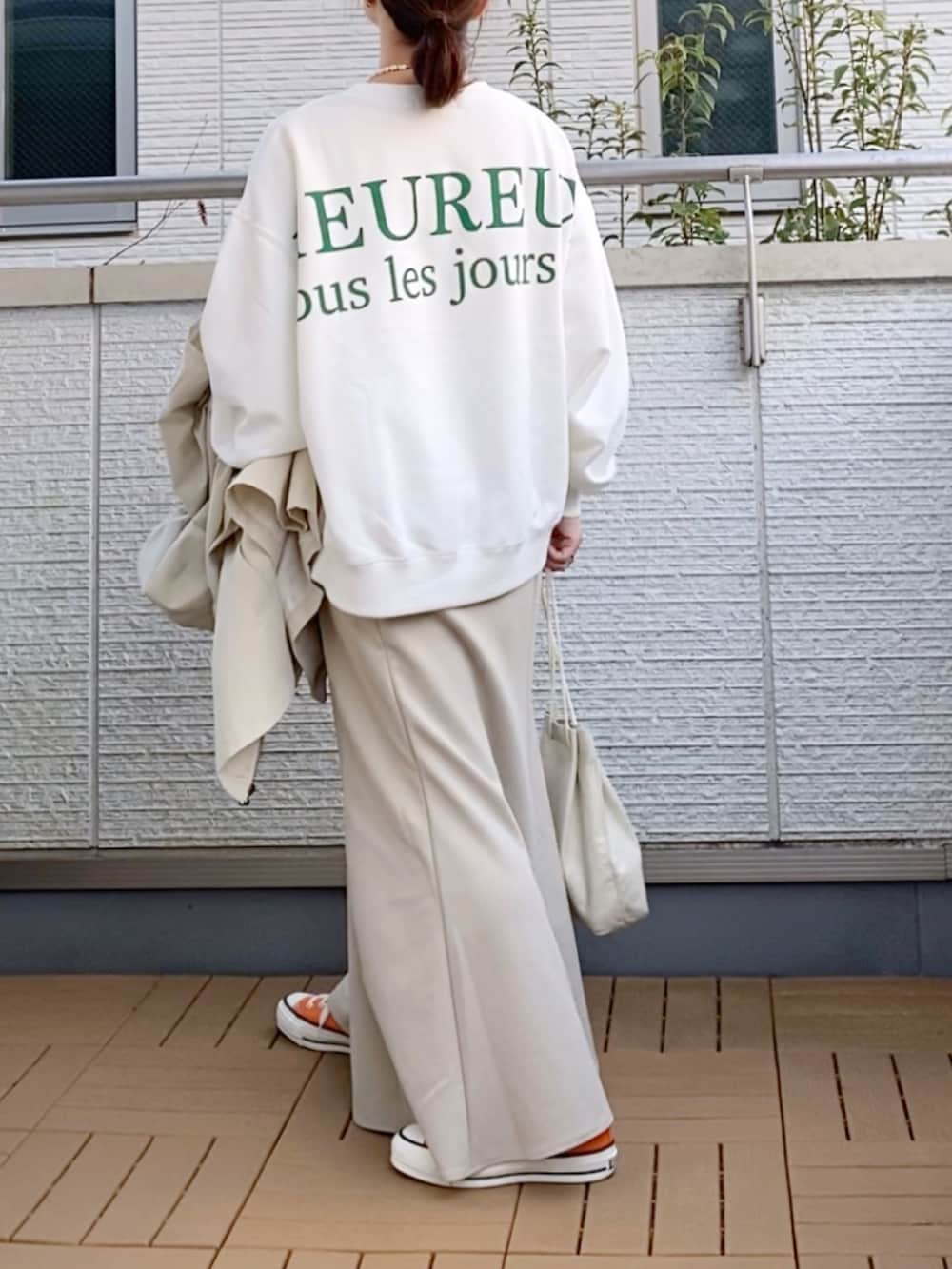 ホワイト系のモッズコート、ベージュ系のスカート、ホワイト系のショルダーバッグを着用したレディースの春コーディネートの3枚目の写真