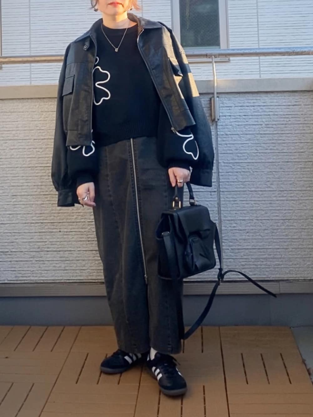 ブラック系のニット/セーター、ブラック系のブルゾン、ブラック系のスカートを着用したレディースの冬コーディネートの2枚目の写真