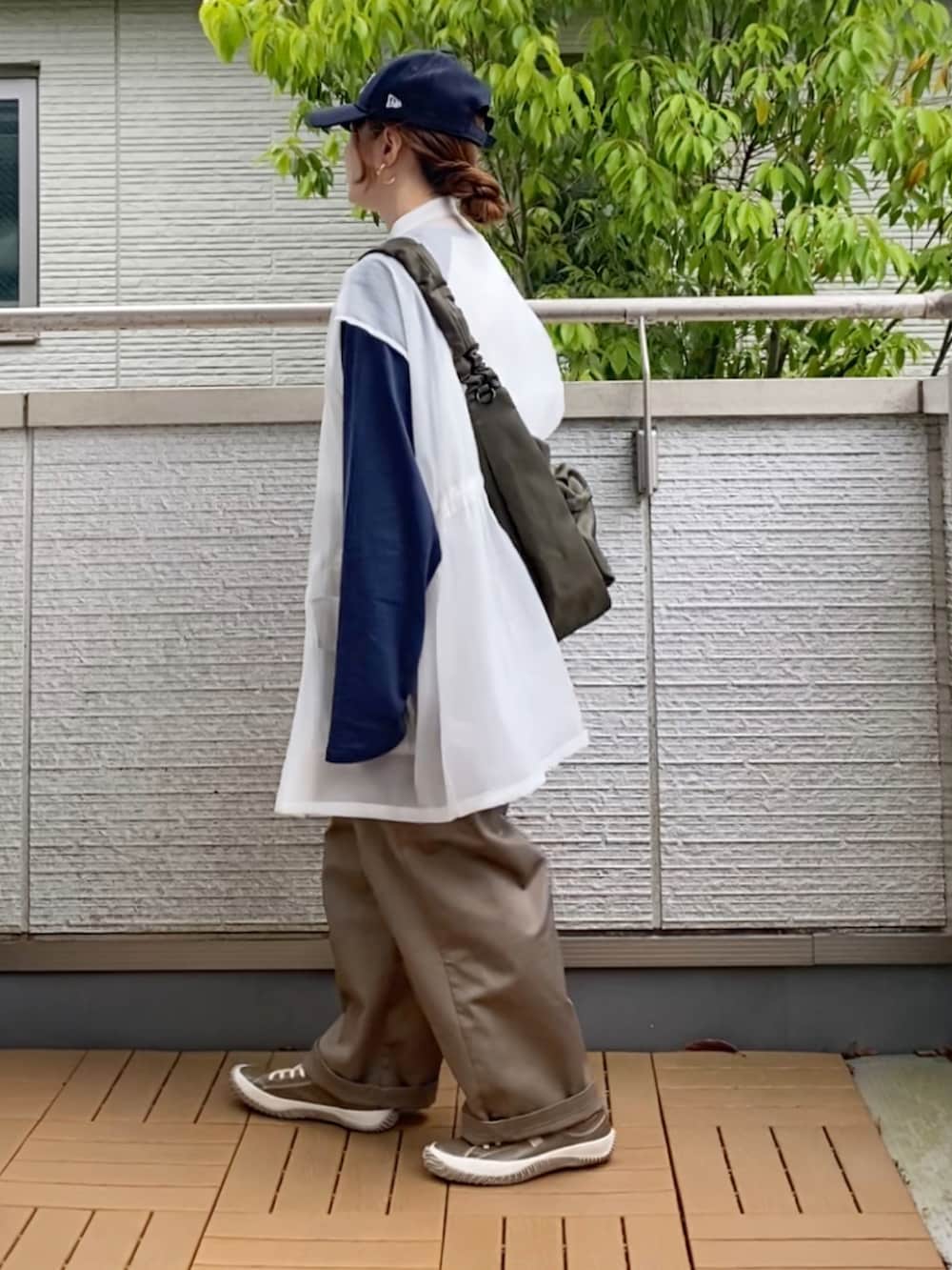 ホワイト系のTシャツ/カットソー、ホワイト系のベスト、ベージュ系のチノパンツを着用したレディースの春コーディネートの3枚目の写真