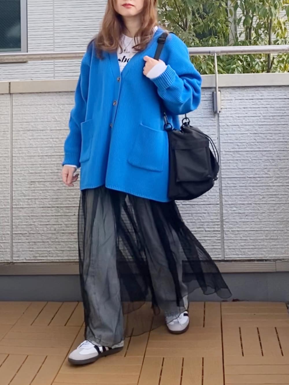 ブルー系のカーディガン/ボレロ、ホワイト系のTシャツ/カットソー、ブラック系のワンピースを着用したレディースの冬コーディネートの2枚目の写真